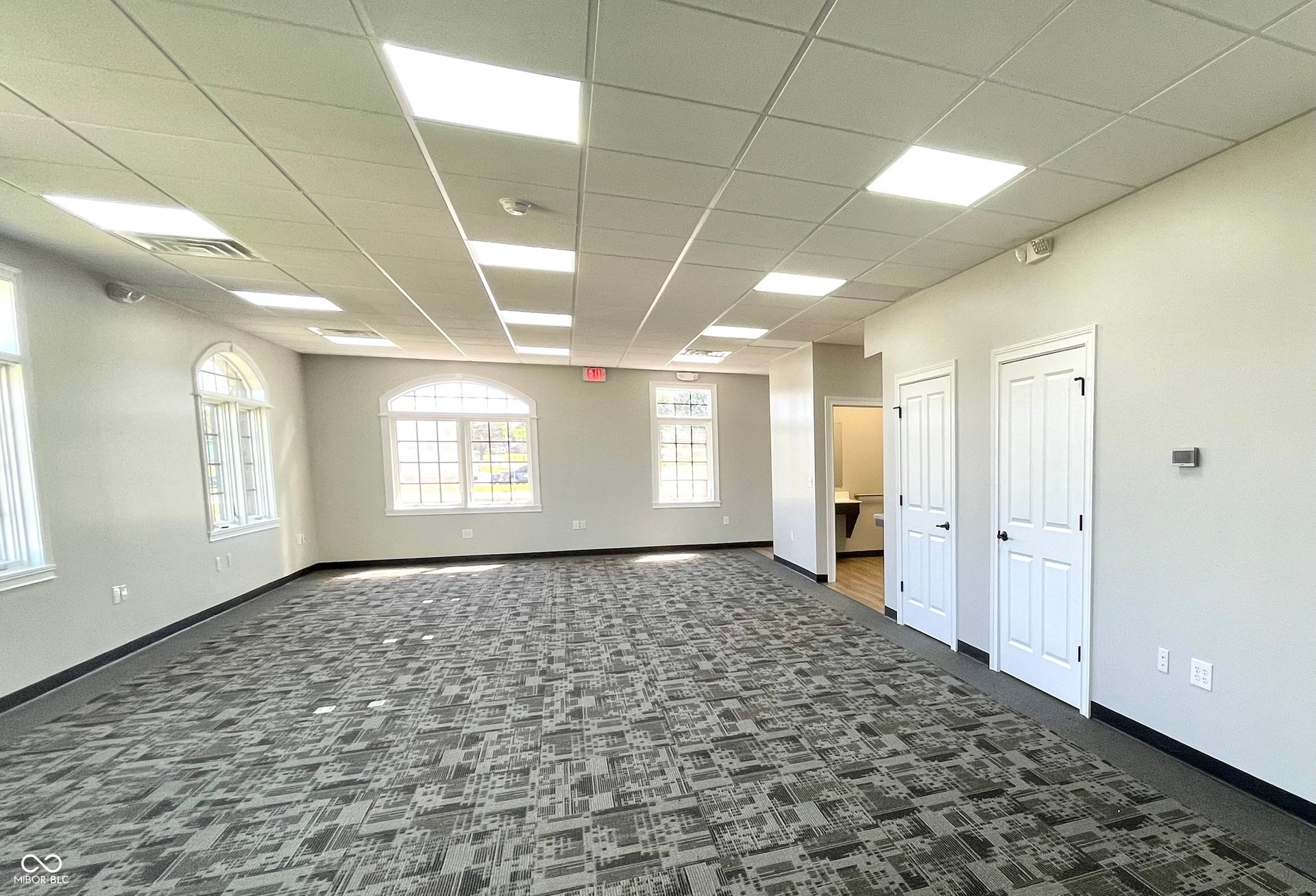 spare room with dark colored carpet and a drop ceiling