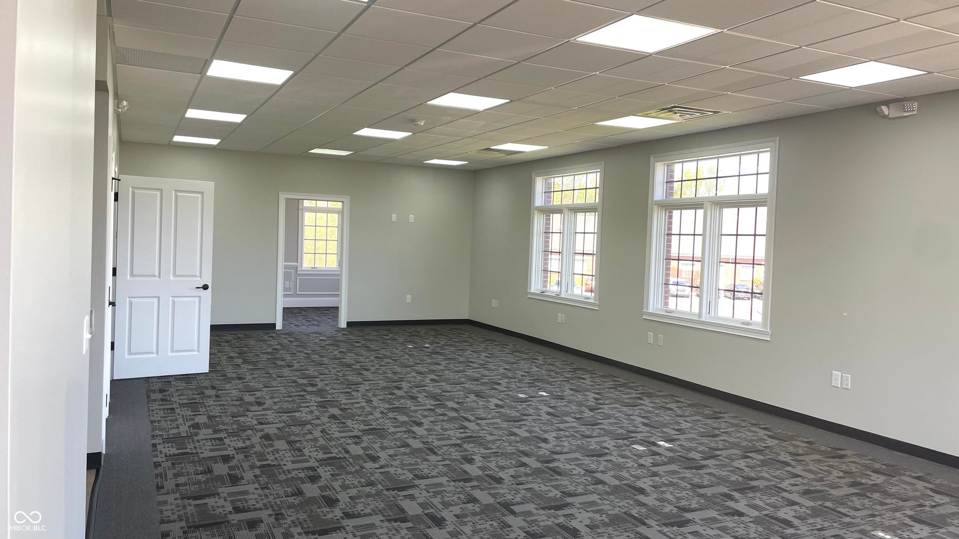 empty room featuring dark colored carpet and a paneled ceiling