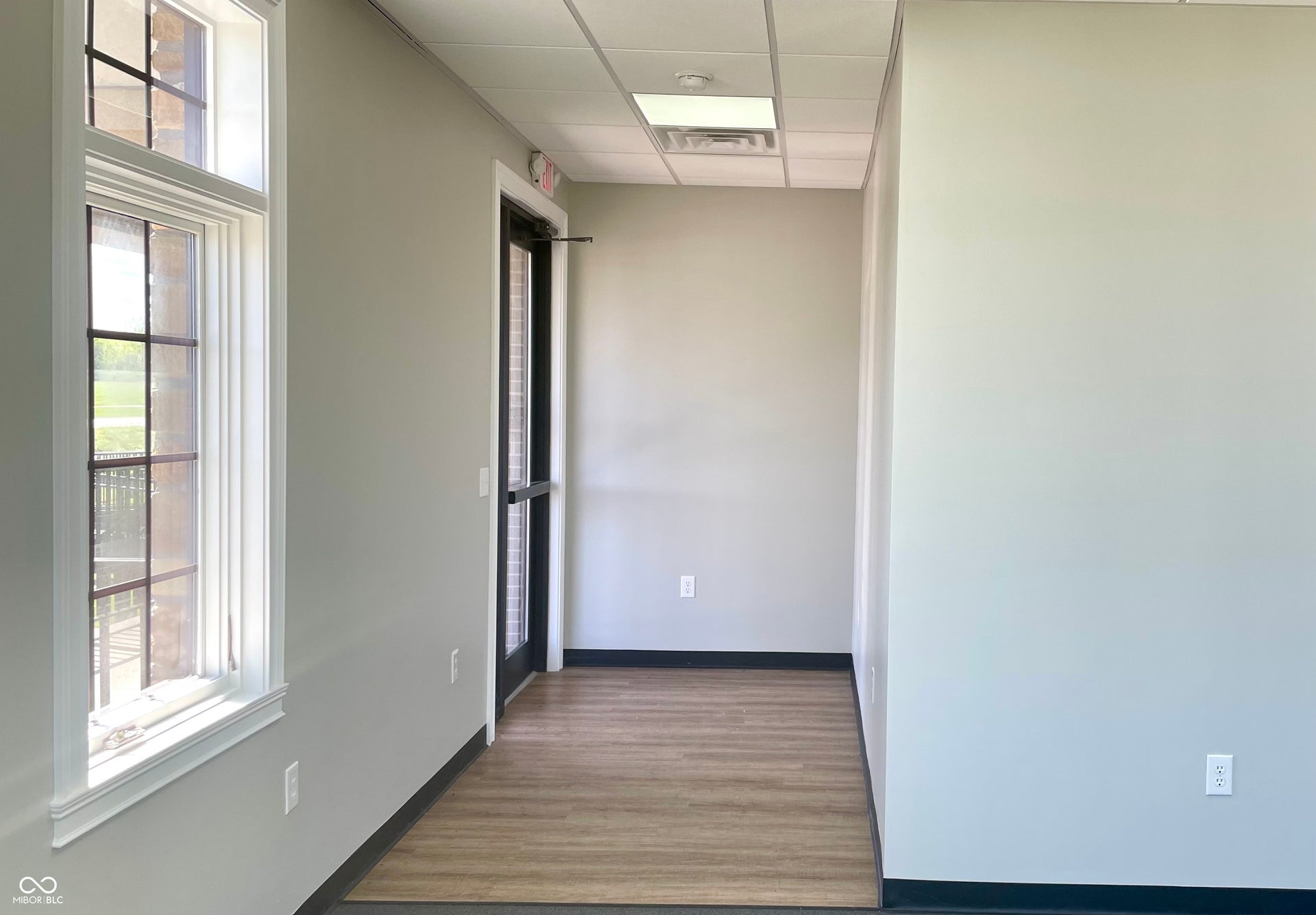 hallway featuring a paneled ceiling and light wood-type flooring