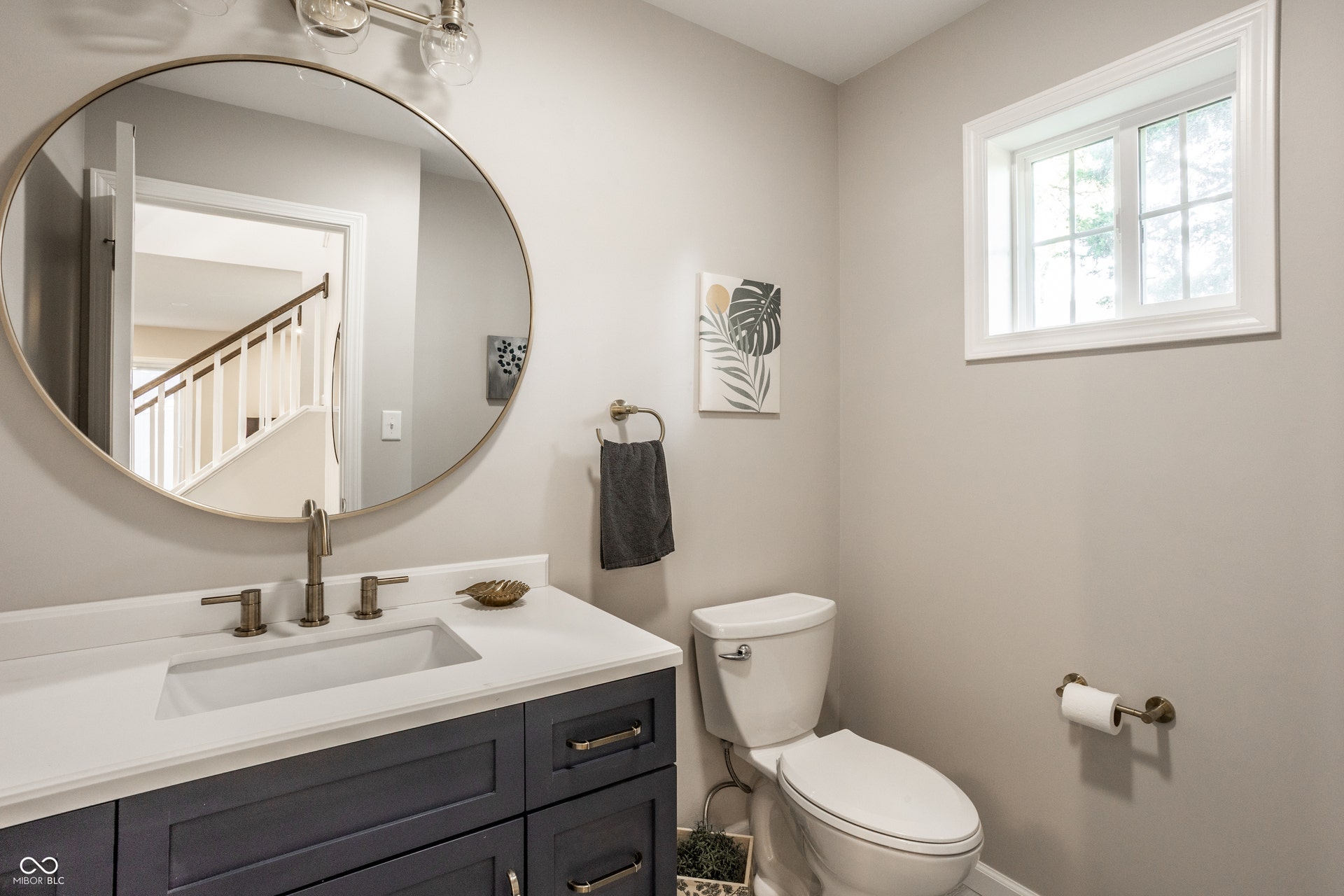 2323 E 57th Street, Indianapolis, IN 46220 Bathroom featuring a vanity with dark cabinetry, integrated sink, and white countertop