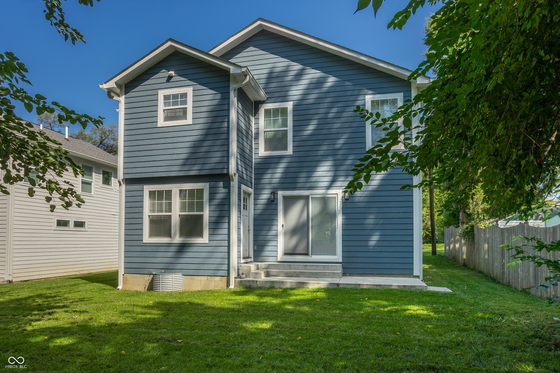 2323 E 57th Street, Indianapolis, IN 46220 Blue horizontal siding exterior with white window trim and a sliding glass door