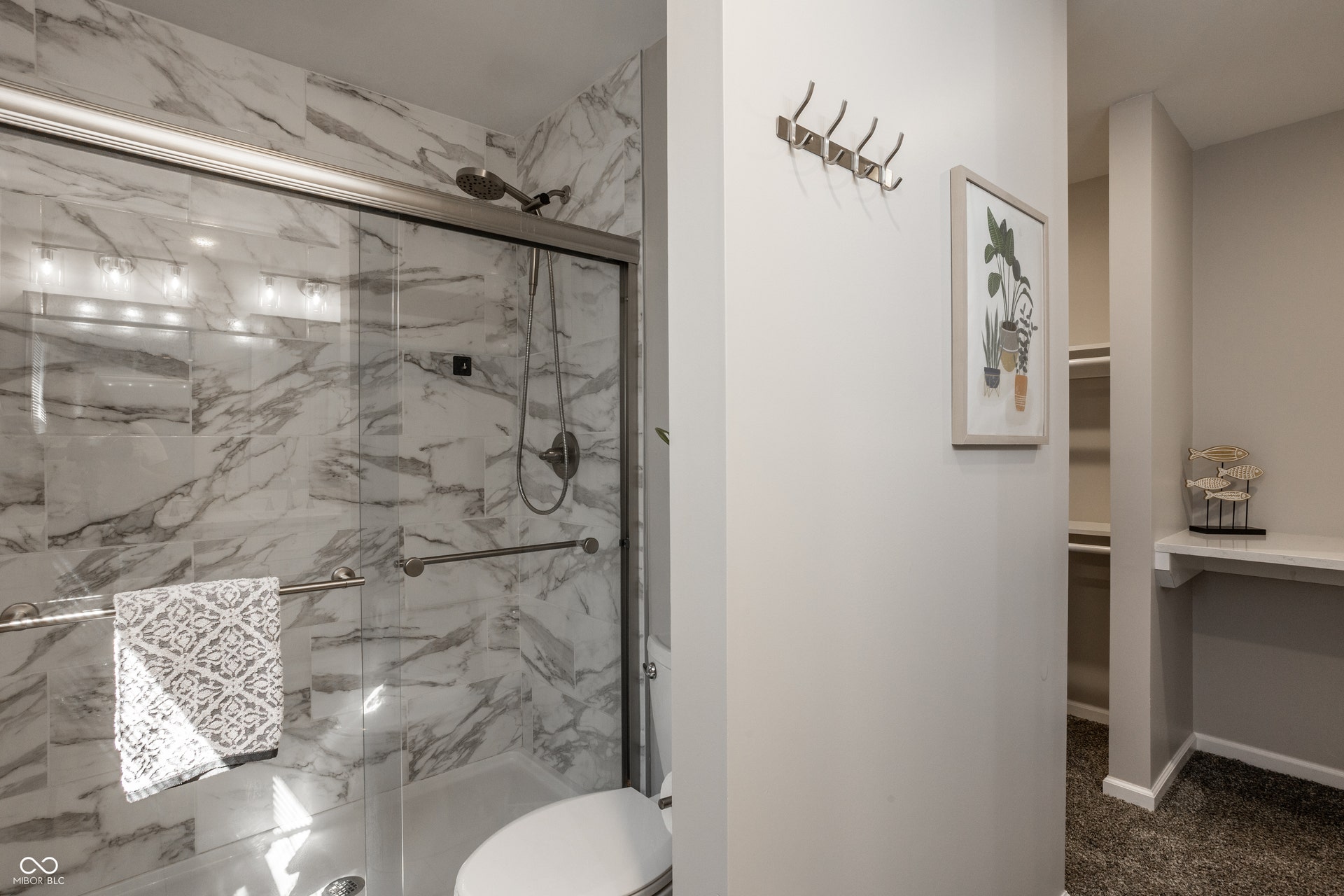 2323 E 57th Street, Indianapolis, IN 46220 Shower with marble-patterned tile, glass enclosure, and mounted shower head