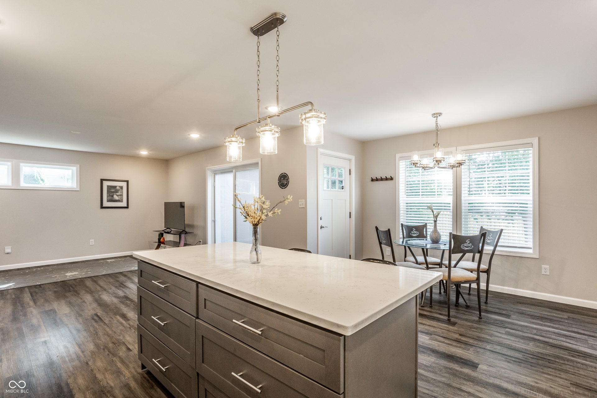 2323 E 57th Street, Indianapolis, IN 46220 Central kitchen island with a light-toned countertop, wood-finish flooring, recessed lighting, and a sliding glass door