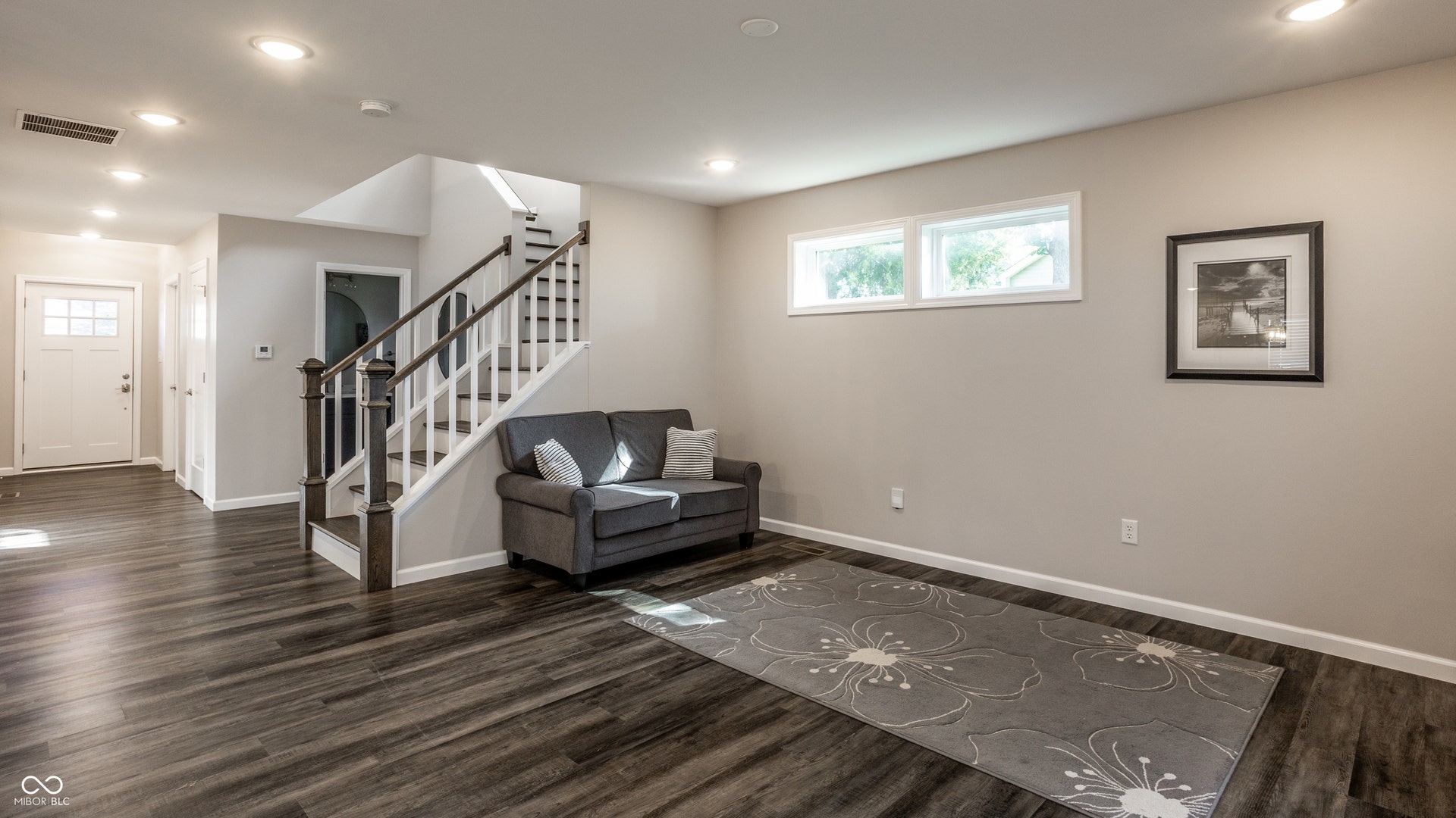 2323 E 57th Street, Indianapolis, IN 46220 Wood-finish flooring throughout, recessed lighting, and a staircase featuring dark wood newel posts and handrails with white risers