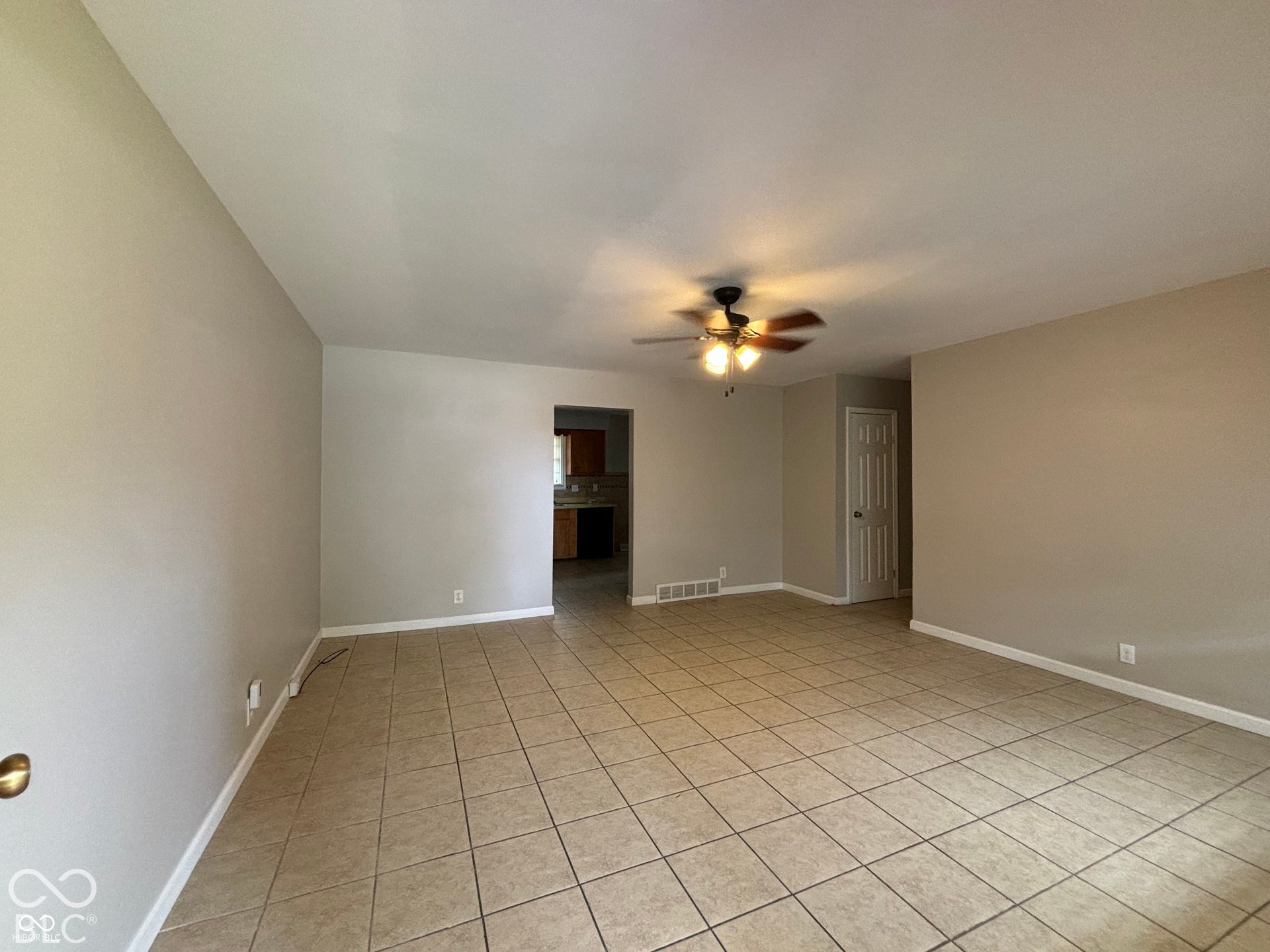 1345 Carroll White Drive, Indianapolis, IN 46219 Expansive room featuring neutral wall tones, tile flooring, and a ceiling fan with integrated lighting