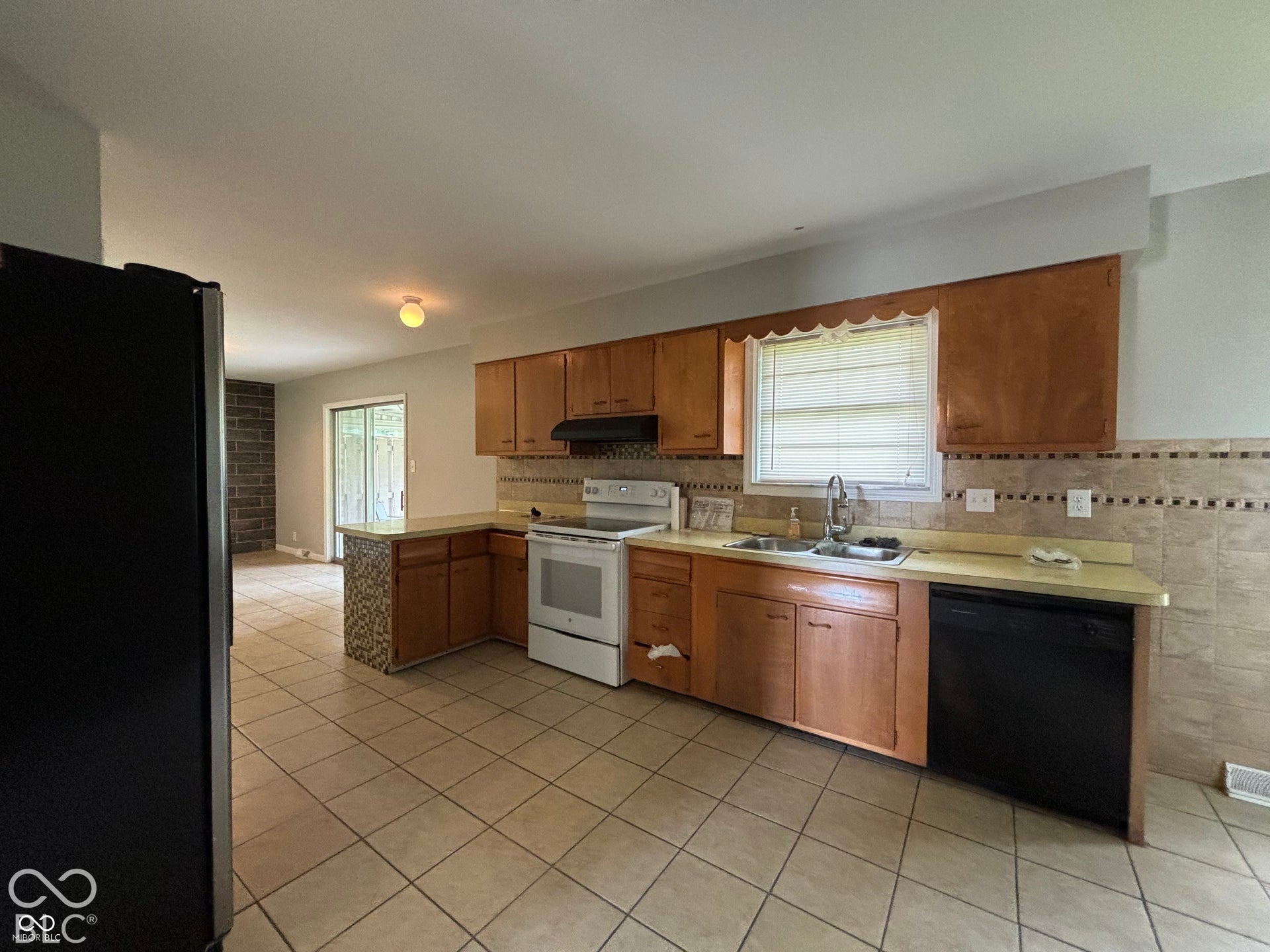 1345 Carroll White Drive, Indianapolis, IN 46219 Kitchen featuring tile flooring, wood cabinetry, built-in dishwasher, and a sliding glass door