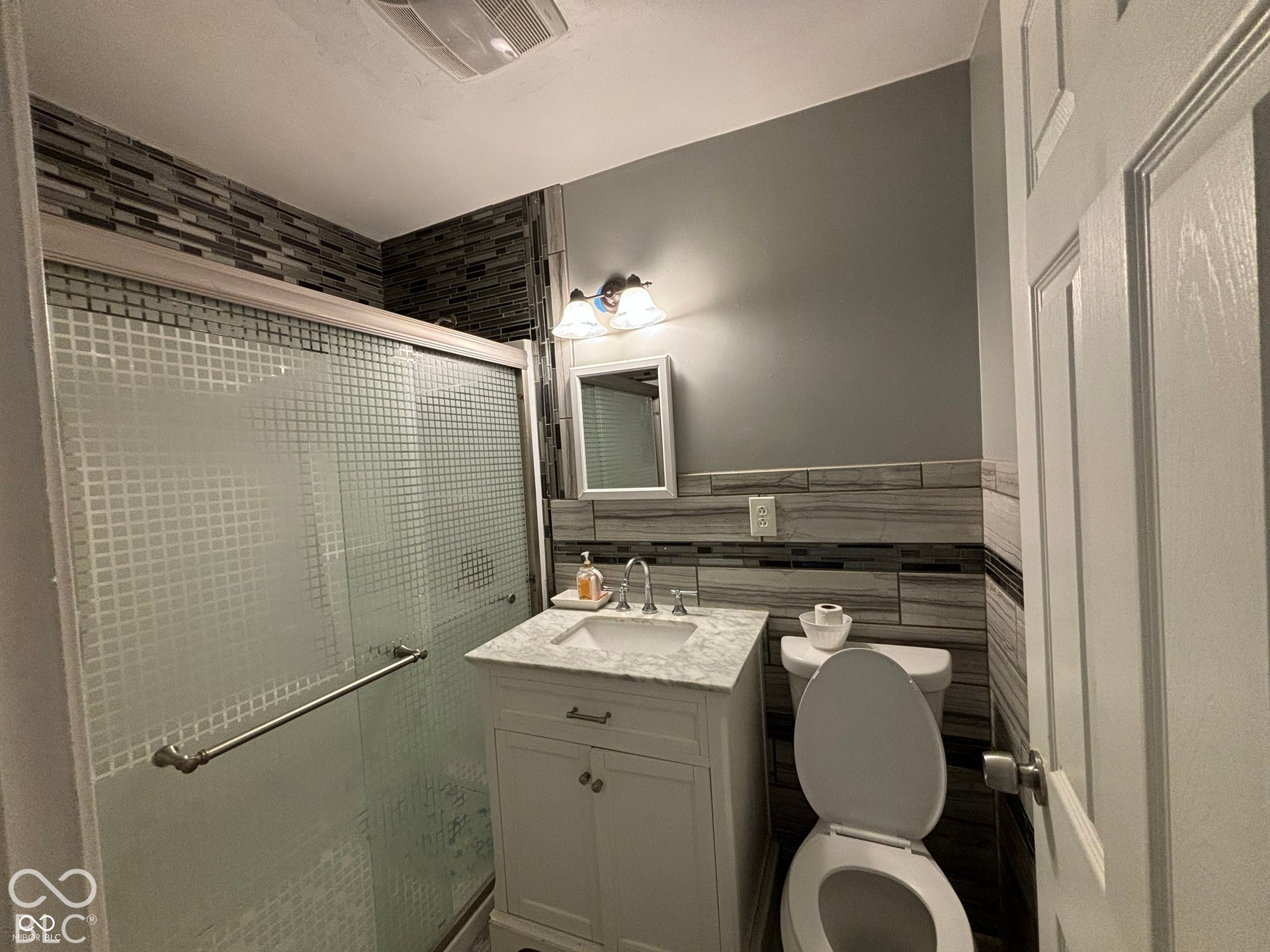 1345 Carroll White Drive, Indianapolis, IN 46219 White vanity with a marble-finish countertop, undermount sink, and chrome faucet