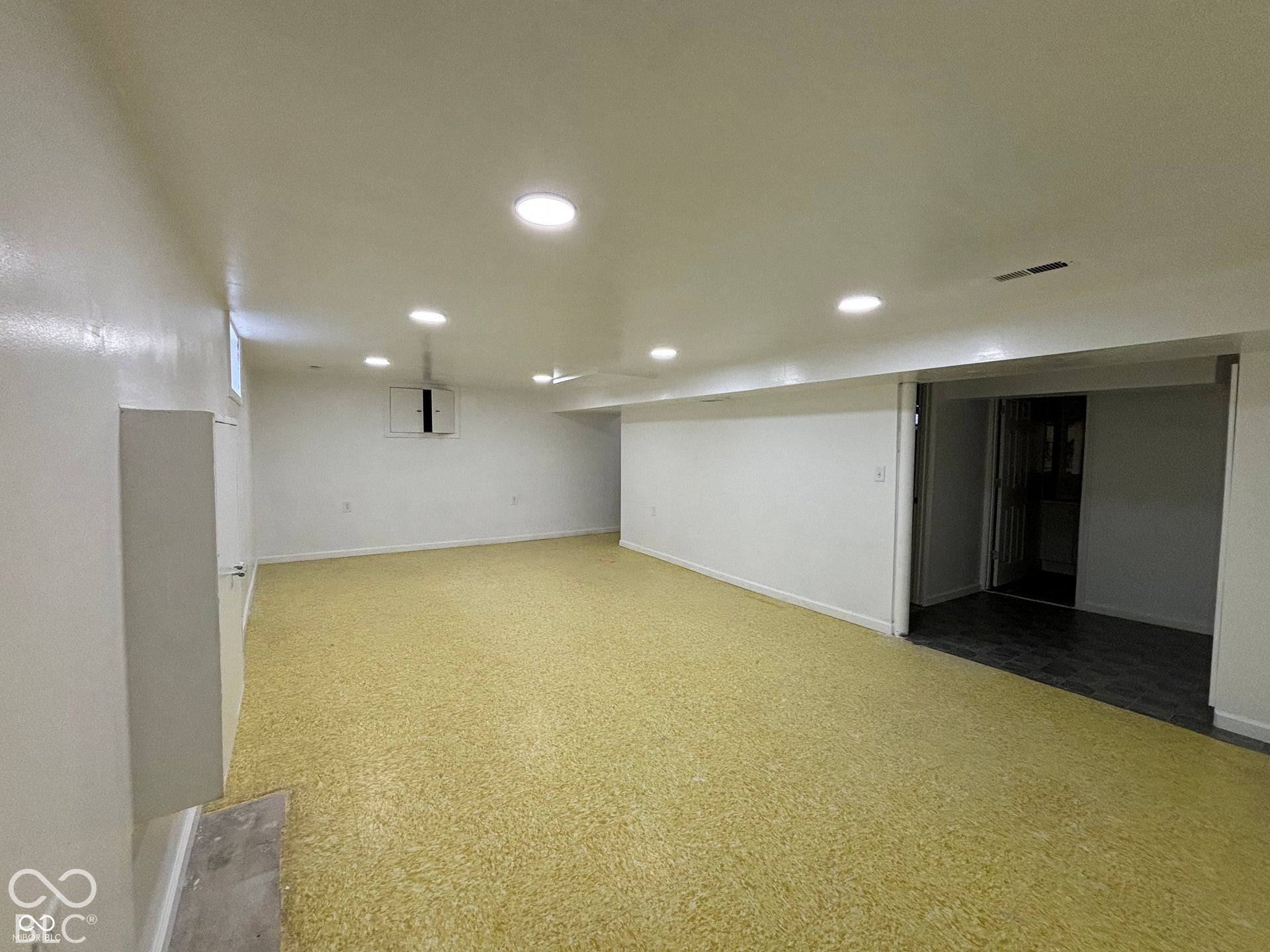 1345 Carroll White Drive, Indianapolis, IN 46219 Recessed ceiling lighting, yellow speckled flooring, white painted walls, built-in storage cabinet, and window