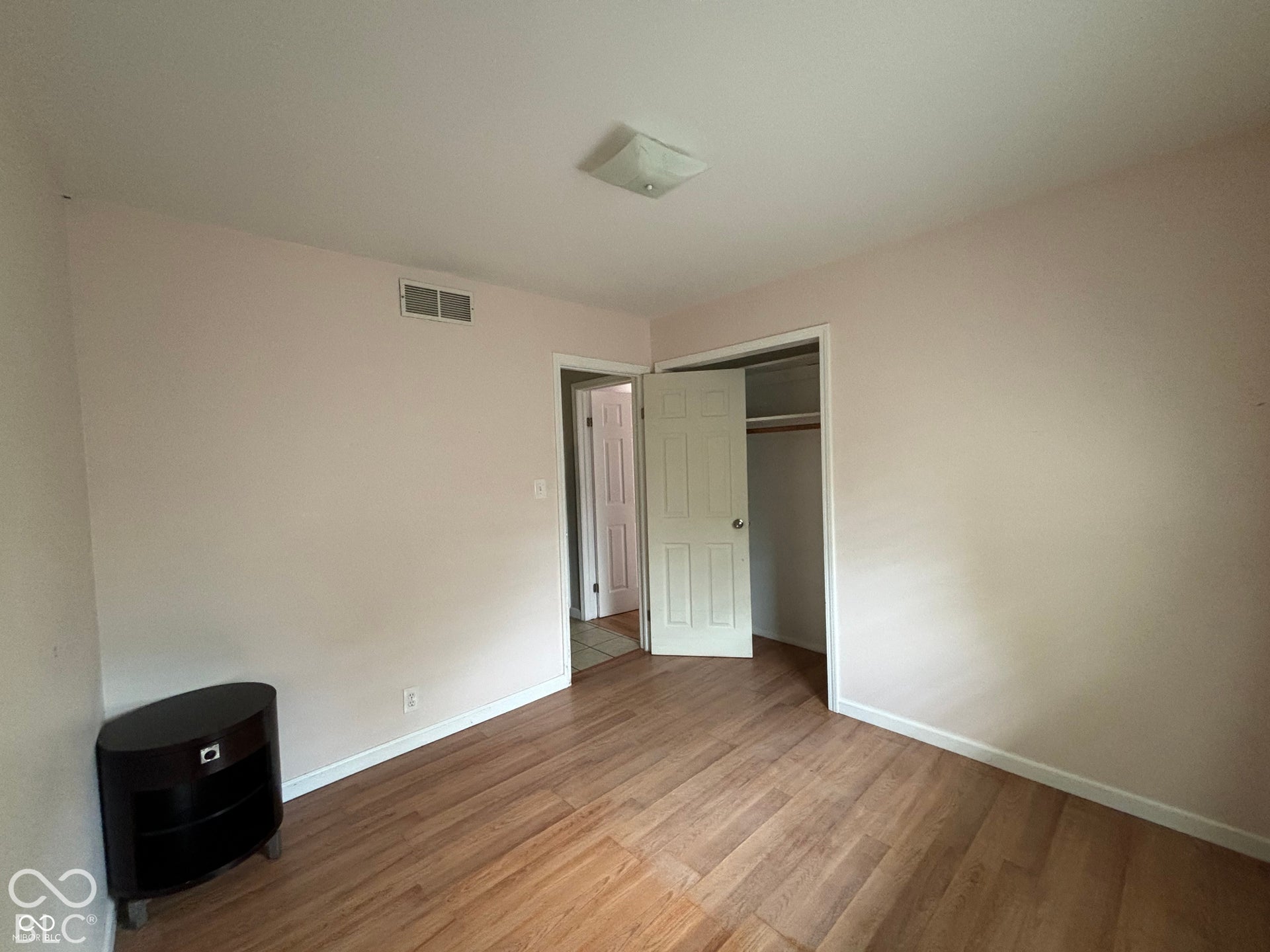 1345 Carroll White Drive, Indianapolis, IN 46219 Wood-finish flooring with light-colored walls, a ceiling-mounted light fixture, and a closet with a bi-fold door