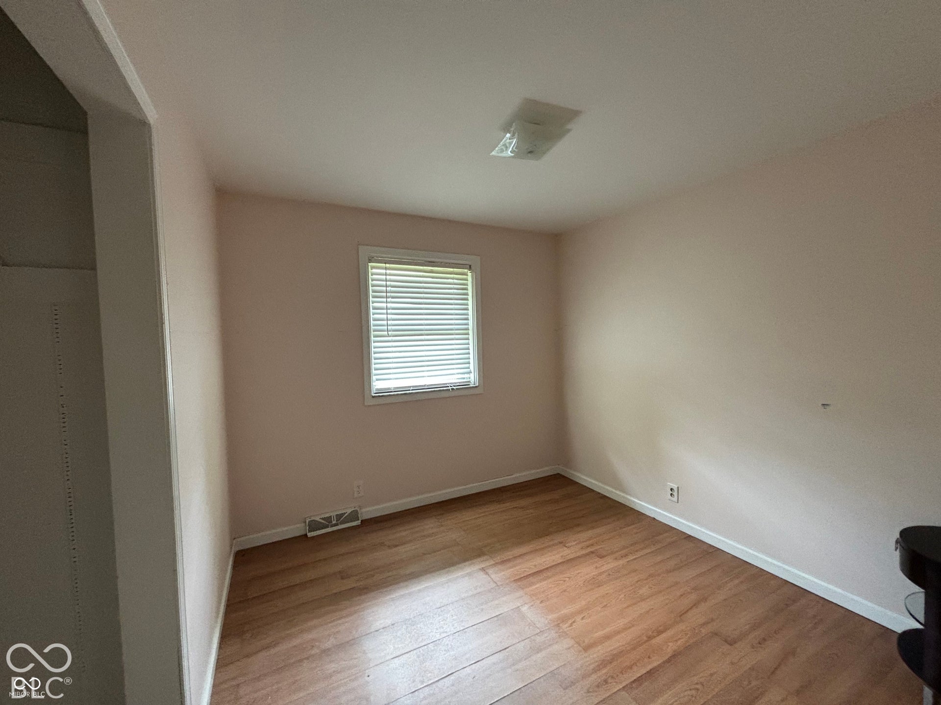 1345 Carroll White Drive, Indianapolis, IN 46219 Wood-finish flooring with a flush-mount ceiling light and a window with blinds