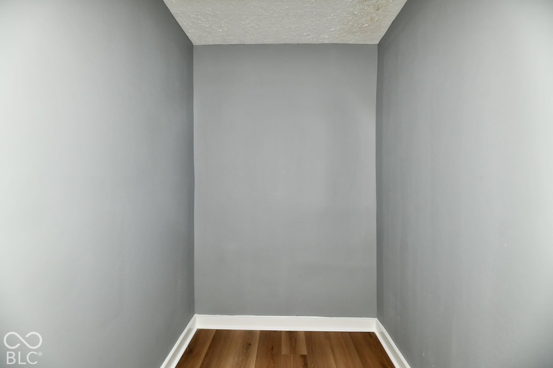 Enclosed space featuring neutral-toned walls and wood-finish flooring
