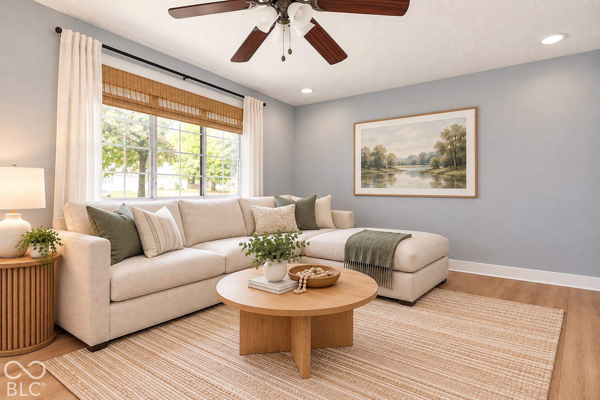 Neutral-toned living space featuring wood-finish flooring, recessed lighting, and a multi-blade ceiling fan with an integrated light fixture