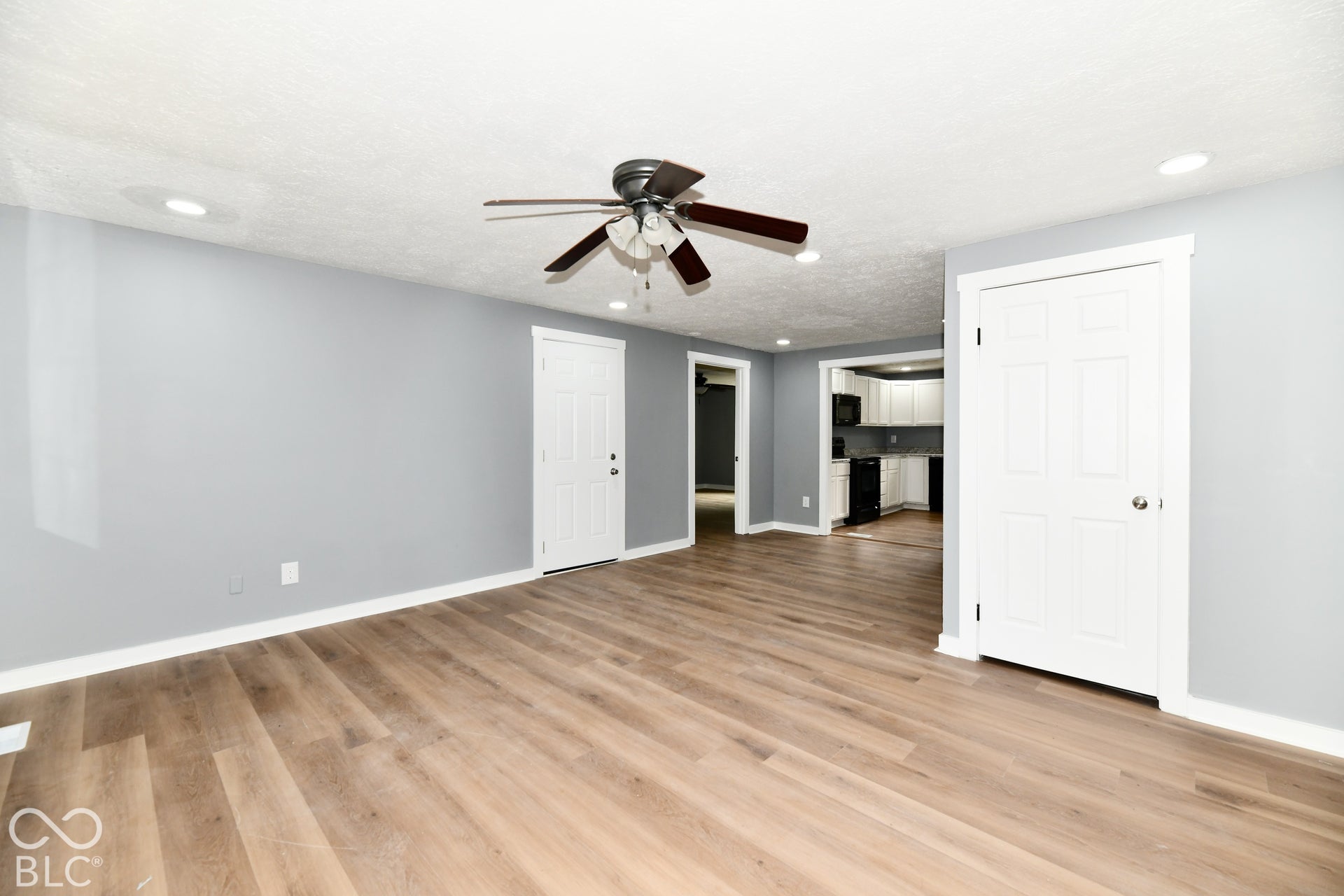 Interior space featuring wood-finish flooring, neutral wall paint, recessed lighting, and a ceiling fan with integrated lighting