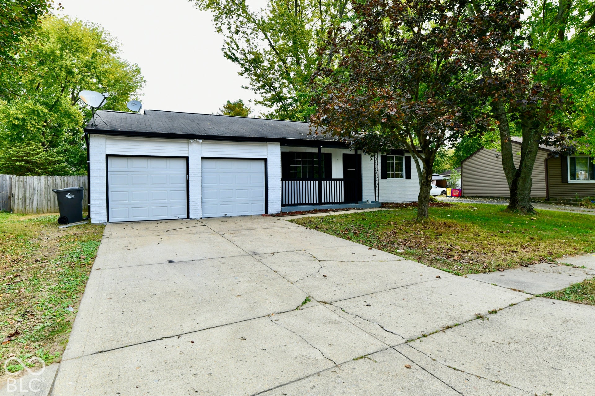 Exterior featuring a two-car garage, concrete driveway, and covered front porch with decorative railing