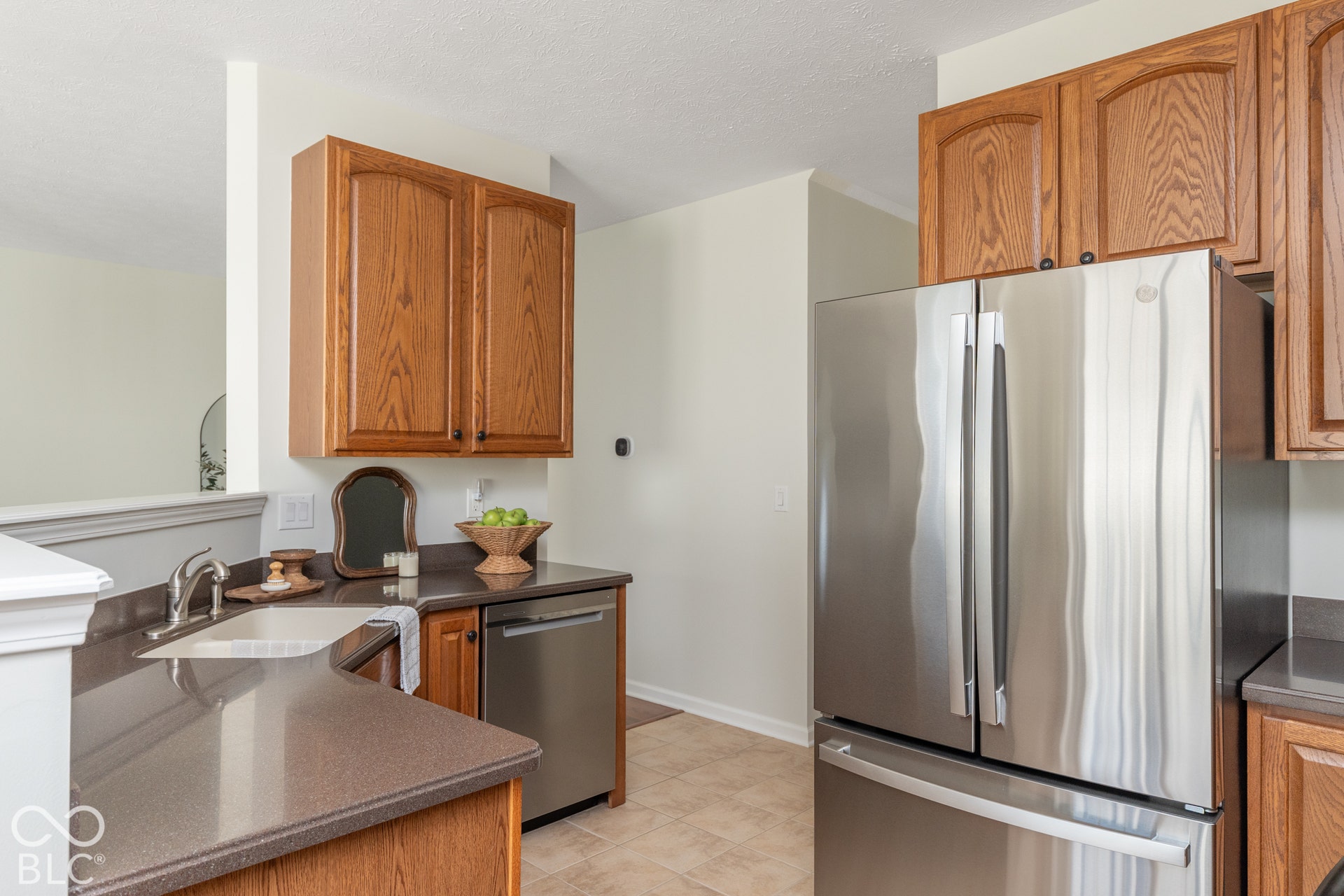 Kitchen featuring wood cabinetry, stainless steel appliances, a stainless steel sink, and solid surface countertops