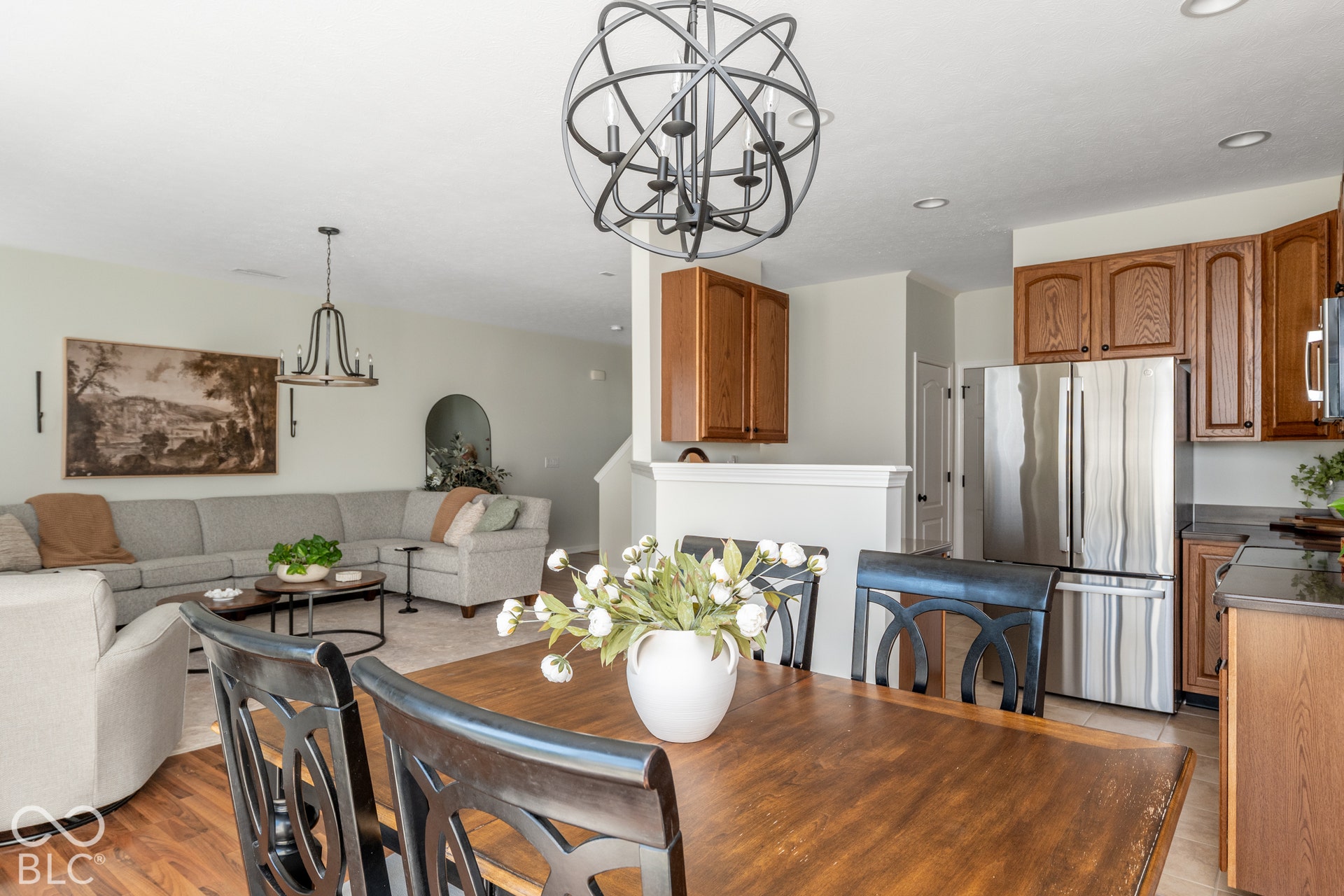 Open concept living area with wood-finish flooring, recessed lighting, and a spherical chandelier