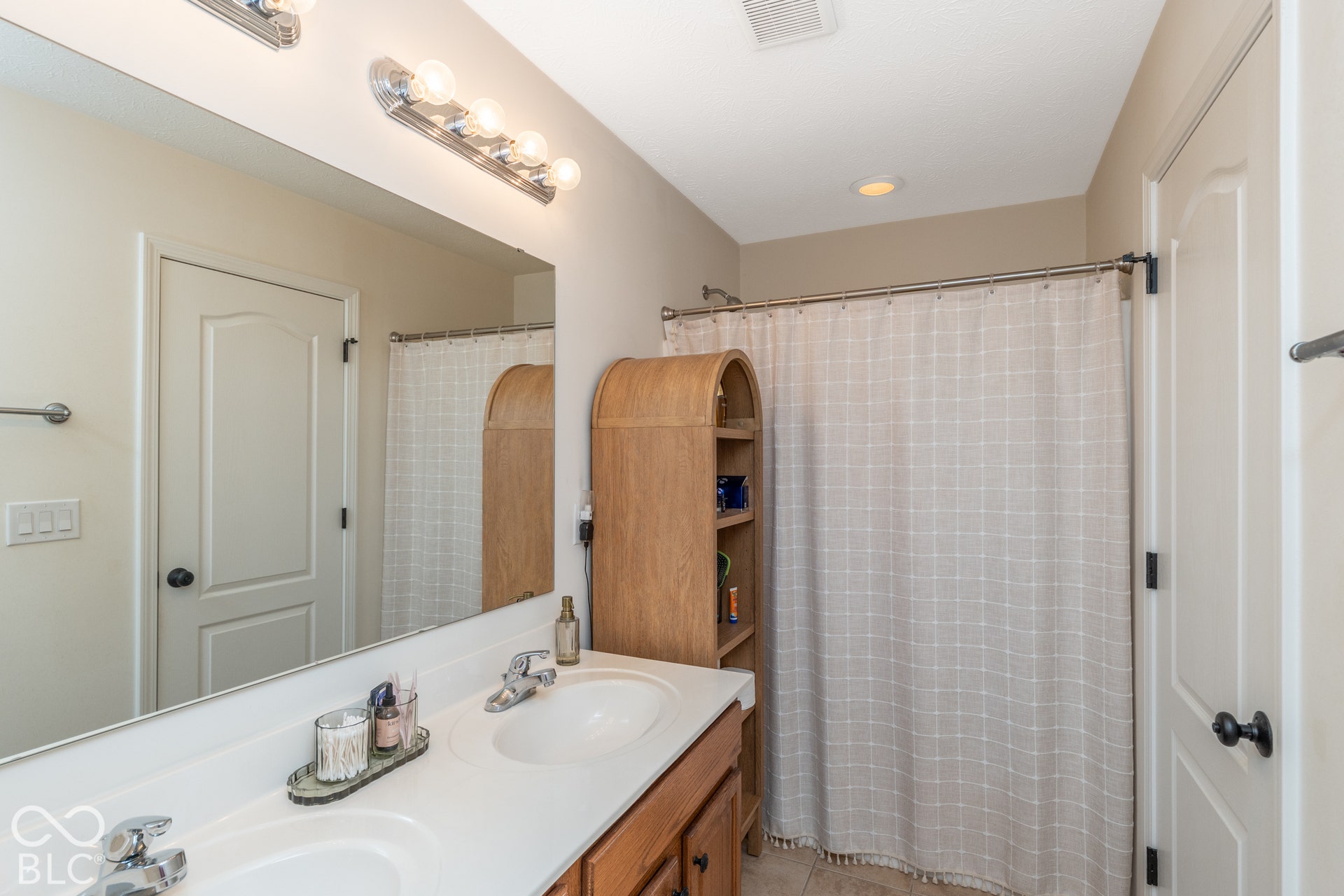 Dual vanity with undermount sinks, chrome fixtures, and a large wall-mounted mirror