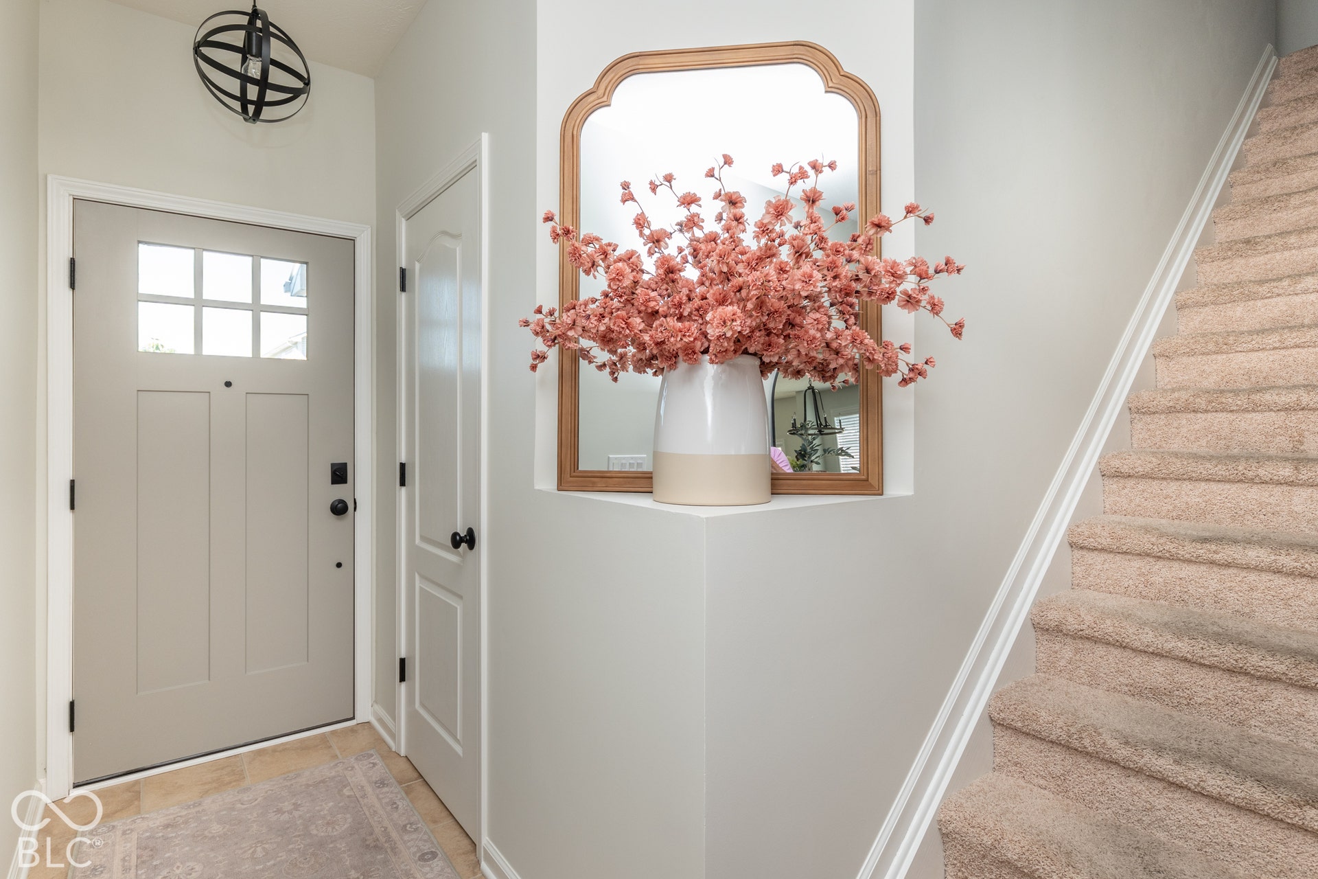 Entryway featuring a paneled door with glass inserts, a black orb-style ceiling fixture, and tile flooring