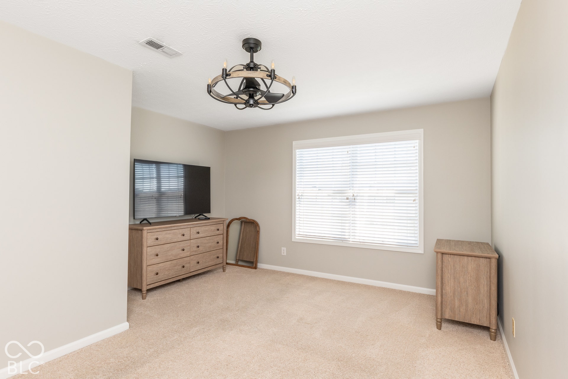Neutral tone wall paint, carpeted flooring, and a window with blinds
