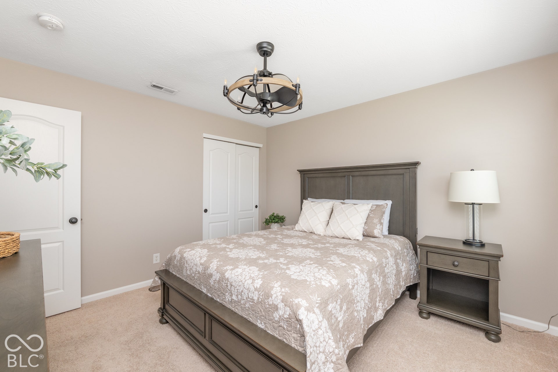 Neutral wall paint, textured carpeting, and a ceiling fan with integrated lighting