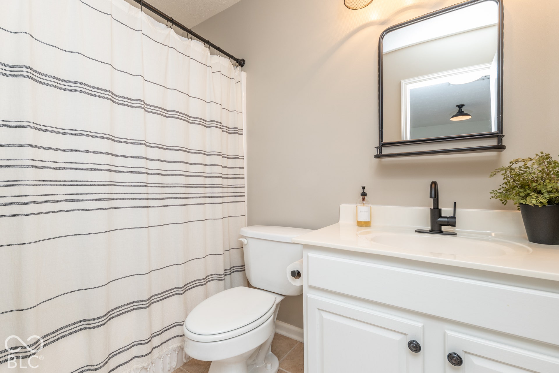 White vanity with cabinet storage, integrated sink, and matte black faucet