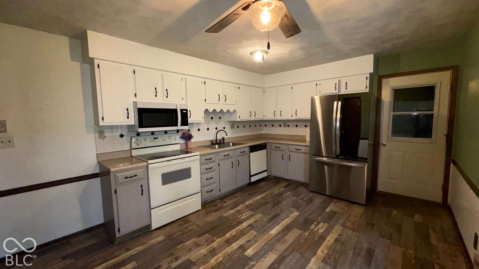 402 E Jackson Street, Farmland, IN 47340 Kitchen featuring wood-finish flooring, white upper cabinetry, and gray lower cabinetry