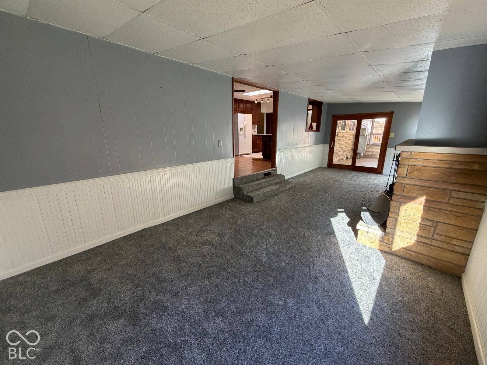 2819 E Edgewood Avenue, Indianapolis, IN 46227 Carpeted flooring, paneled walls, stone-faced fireplace, and sliding glass door