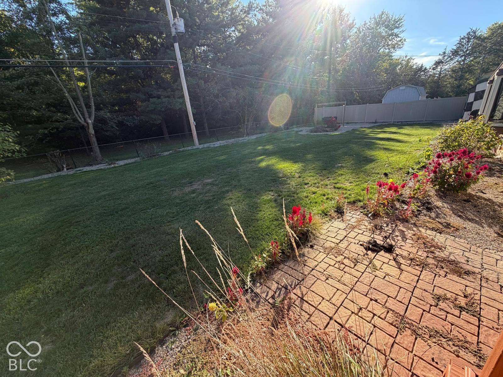 2819 E Edgewood Avenue, Indianapolis, IN 46227 Expansive backyard featuring a brick paver patio, a manicured lawn, and a light-toned privacy fence