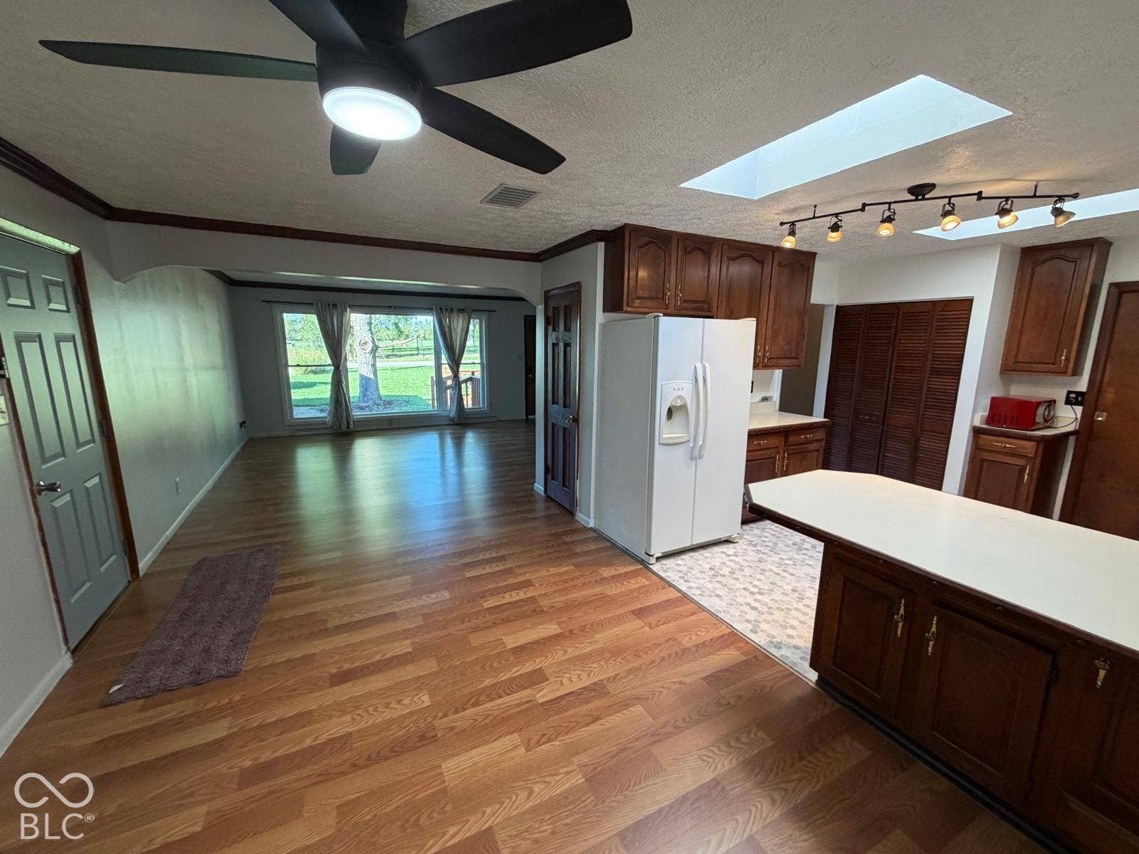 2819 E Edgewood Avenue, Indianapolis, IN 46227 Wood-finish flooring throughout, kitchen with wood cabinetry, and a central island with a solid surface countertop