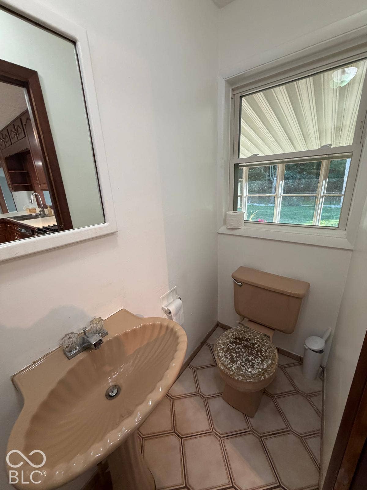 2819 E Edgewood Avenue, Indianapolis, IN 46227 Pedestal sink with a shell-inspired basin, a functional window, and geometric floor tiling