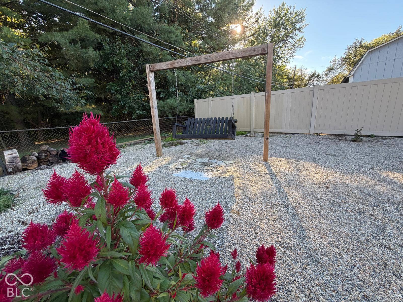 2819 E Edgewood Avenue, Indianapolis, IN 46227 Gravel ground cover, wood swing frame with swing, light-toned privacy fencing, and surrounding mature trees