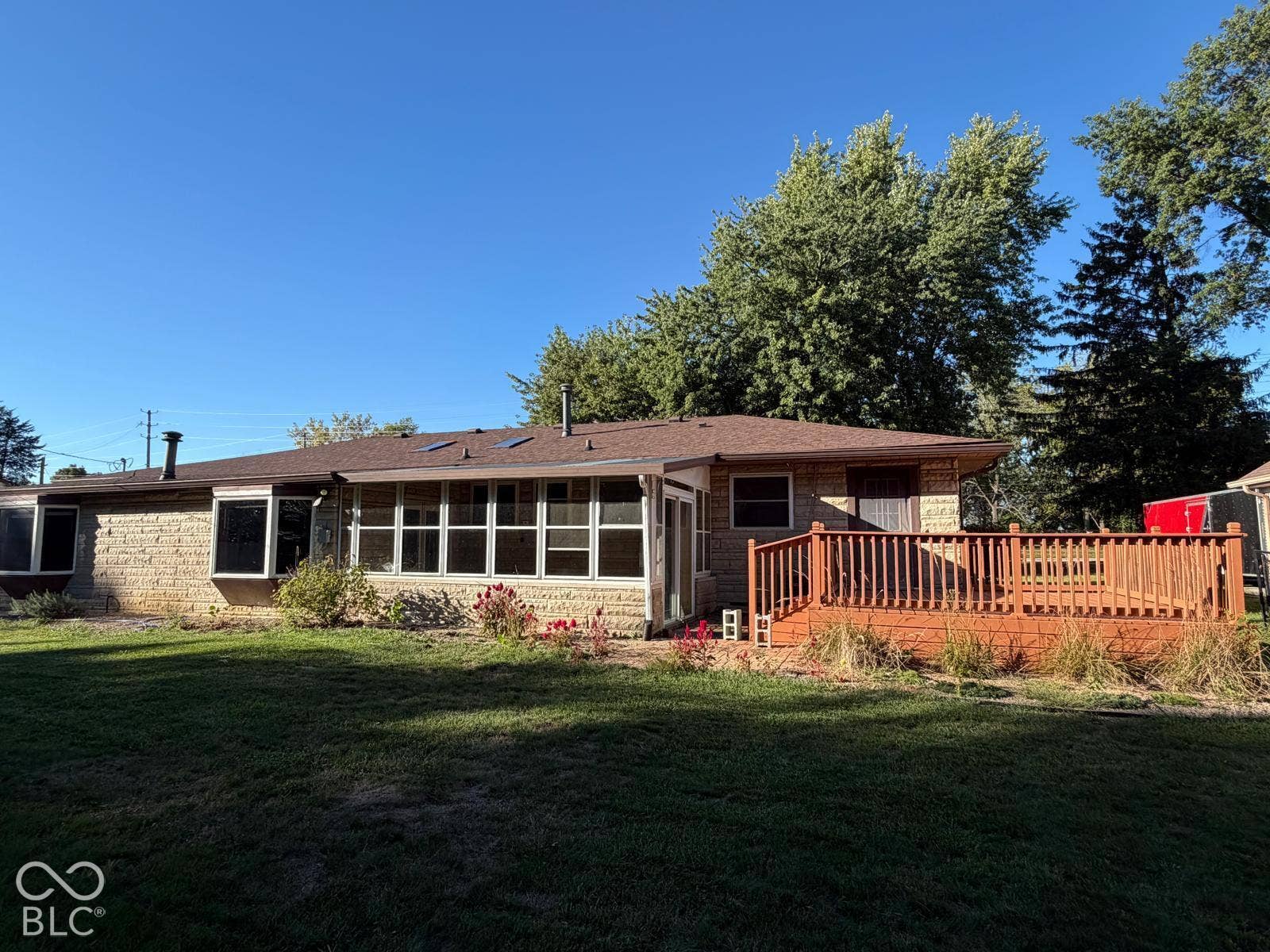 2819 E Edgewood Avenue, Indianapolis, IN 46227 Expansive wood deck, full-light sunroom, bay window, light brick exterior, and a shingle roof
