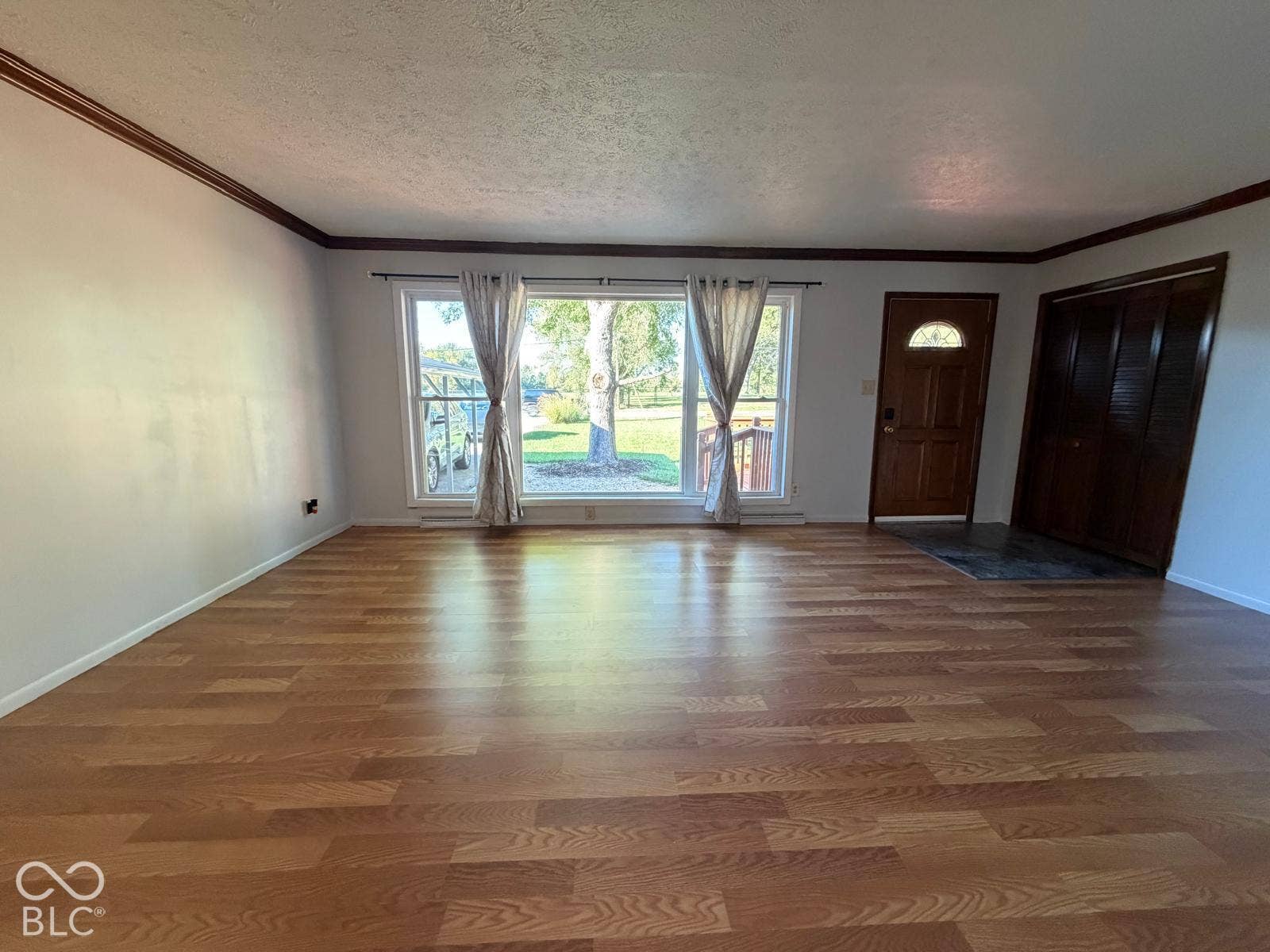 2819 E Edgewood Avenue, Indianapolis, IN 46227 Wood-finish flooring throughout, with a front entry door featuring an arched window, and a built-in closet with bi-fold doors
