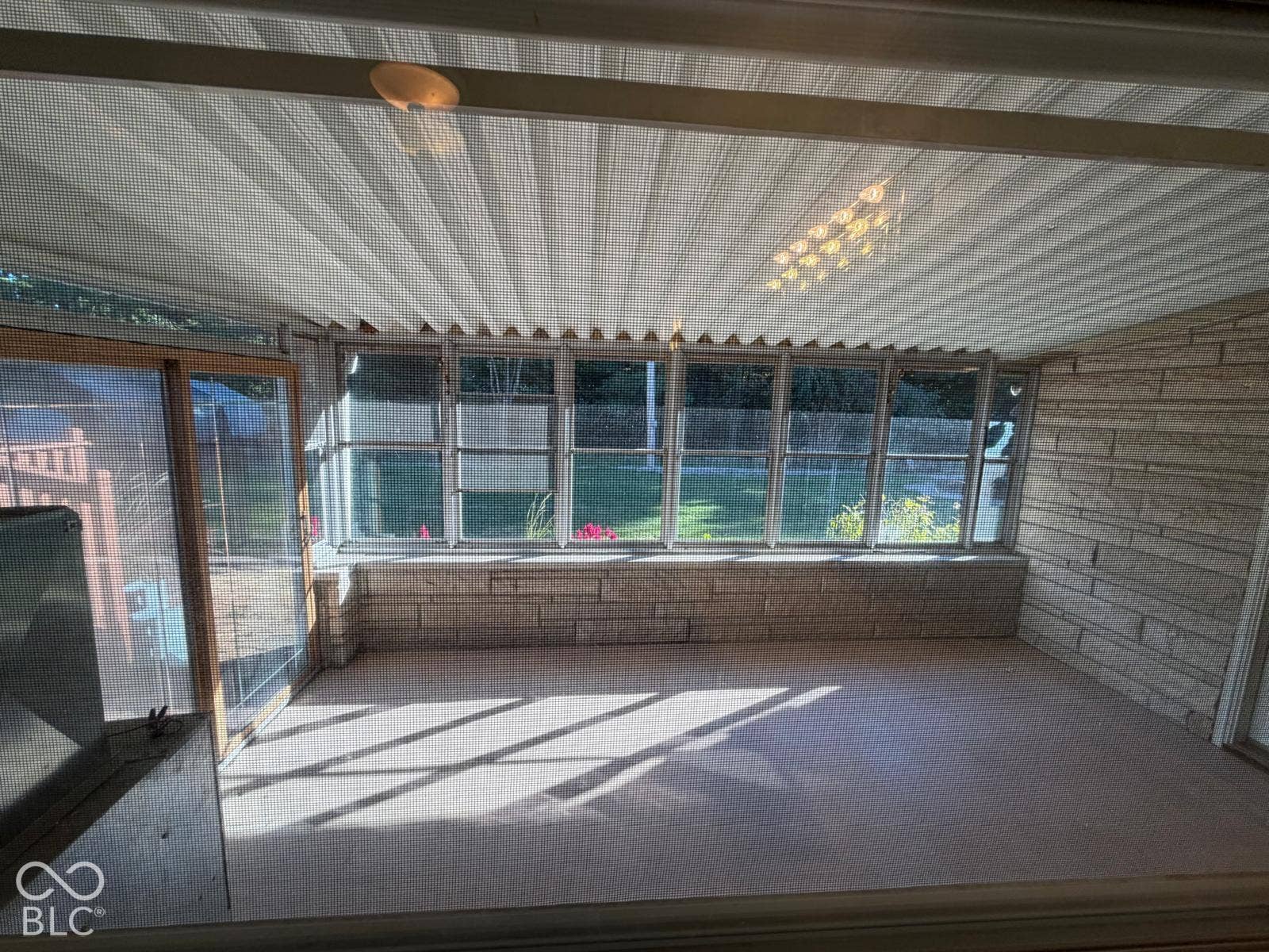 2819 E Edgewood Avenue, Indianapolis, IN 46227 Enclosed sunroom with stone veneer walls, multiple windows, and a textured ceiling