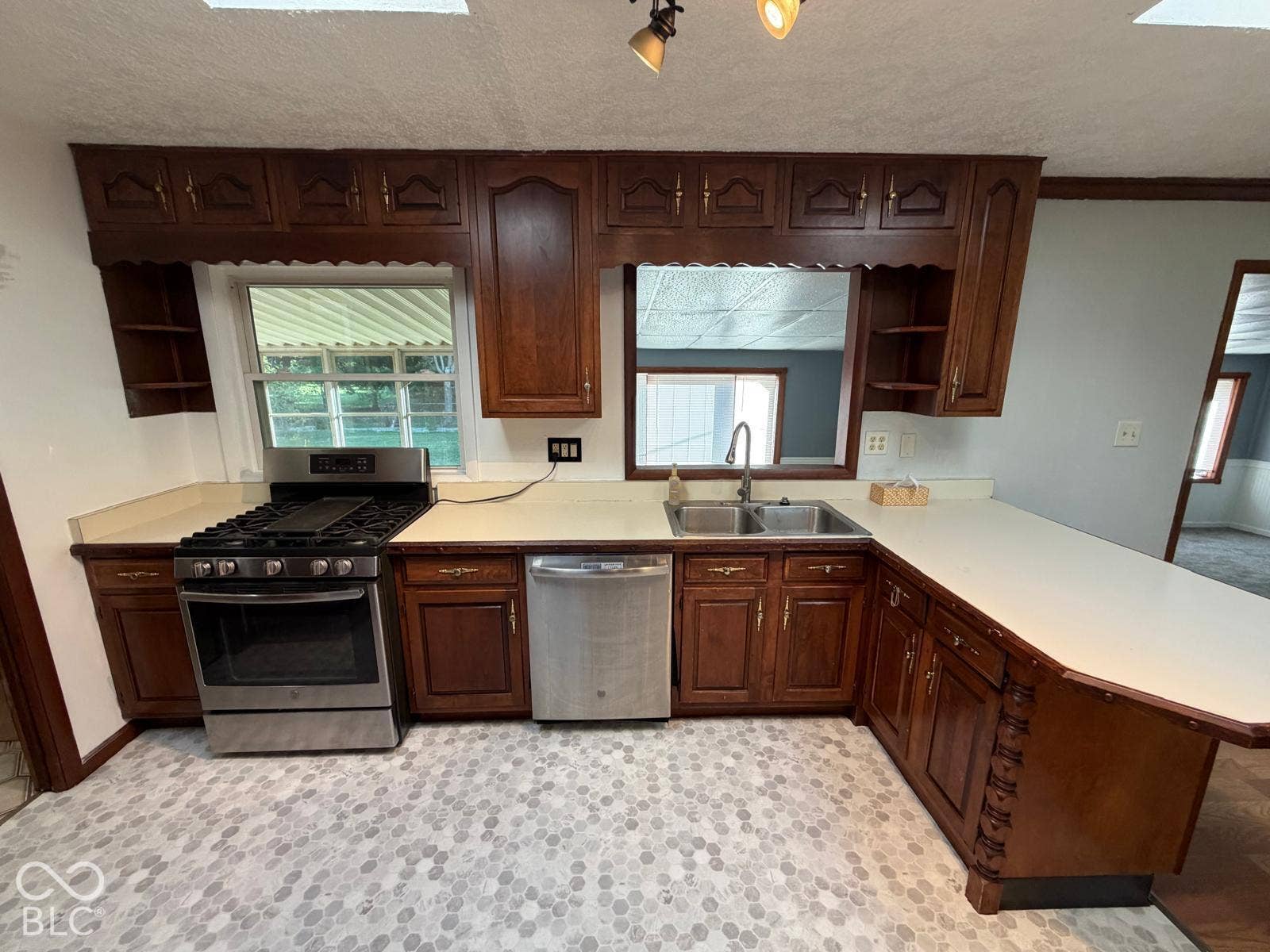 2819 E Edgewood Avenue, Indianapolis, IN 46227 Kitchen featuring wood-finish cabinetry, light countertops, stainless steel appliances, and patterned tile flooring