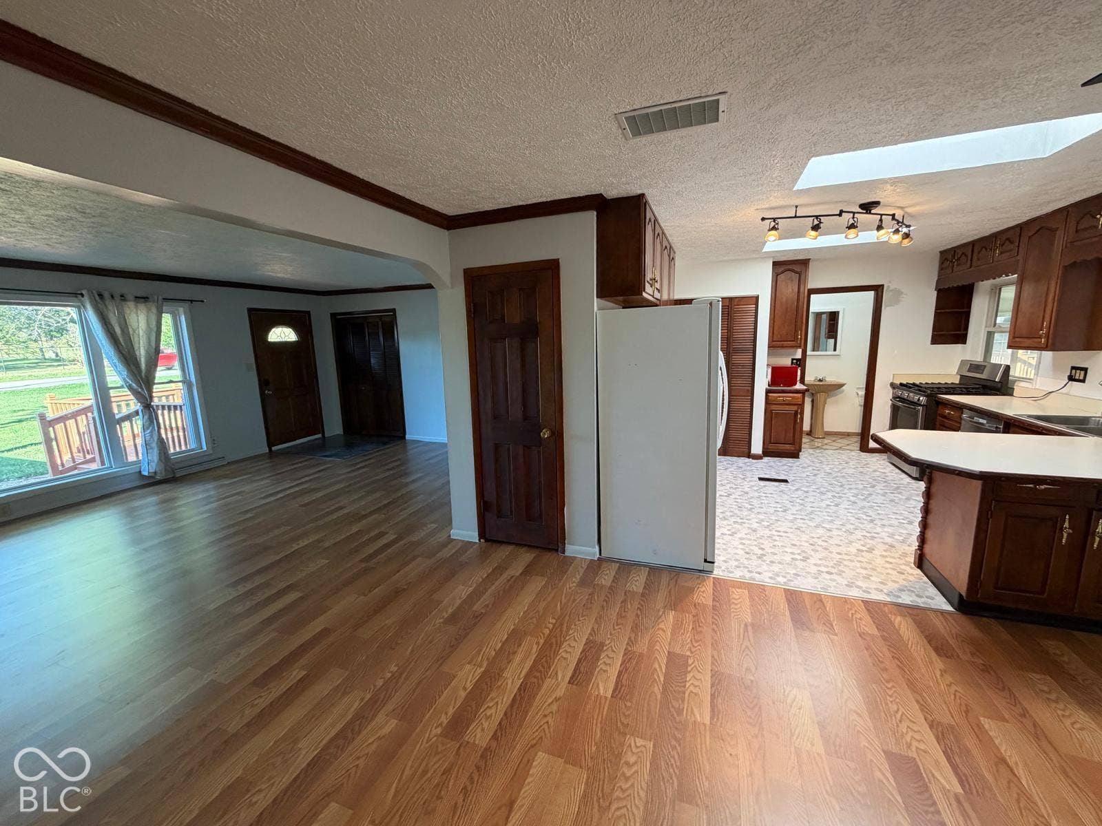2819 E Edgewood Avenue, Indianapolis, IN 46227 Wood-finish flooring, kitchen with dark wood cabinetry, white countertops, built-in range, and a skylight