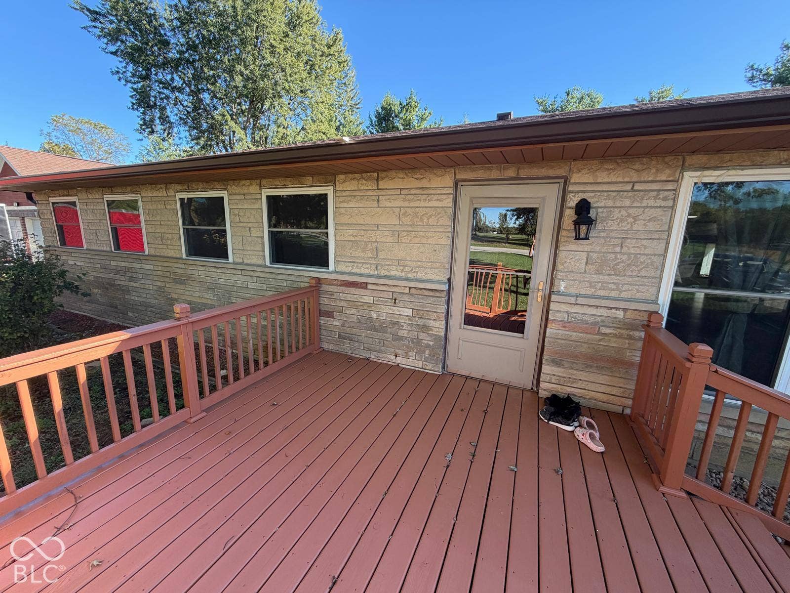 2819 E Edgewood Avenue, Indianapolis, IN 46227 Expansive outdoor deck with wood railing, leading to a glass-paneled exterior door