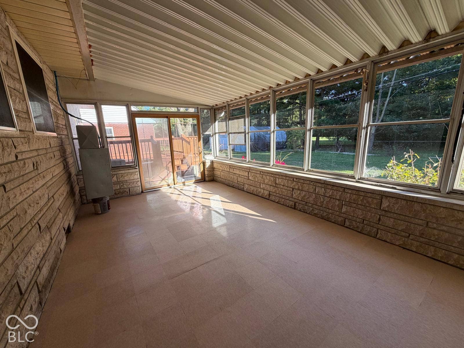 2819 E Edgewood Avenue, Indianapolis, IN 46227 Sunroom featuring a stone-clad wall, multiple large windows, and a sliding glass door