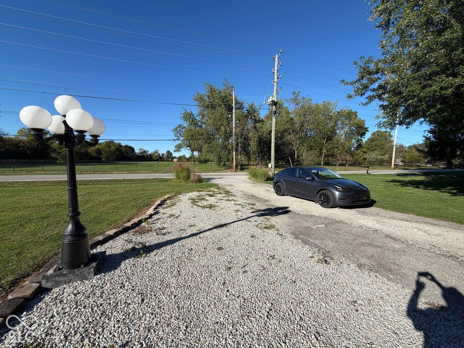 2819 E Edgewood Avenue, Indianapolis, IN 46227 Gravel driveway with integrated asphalt track, featuring a decorative multi-bulb lamp post