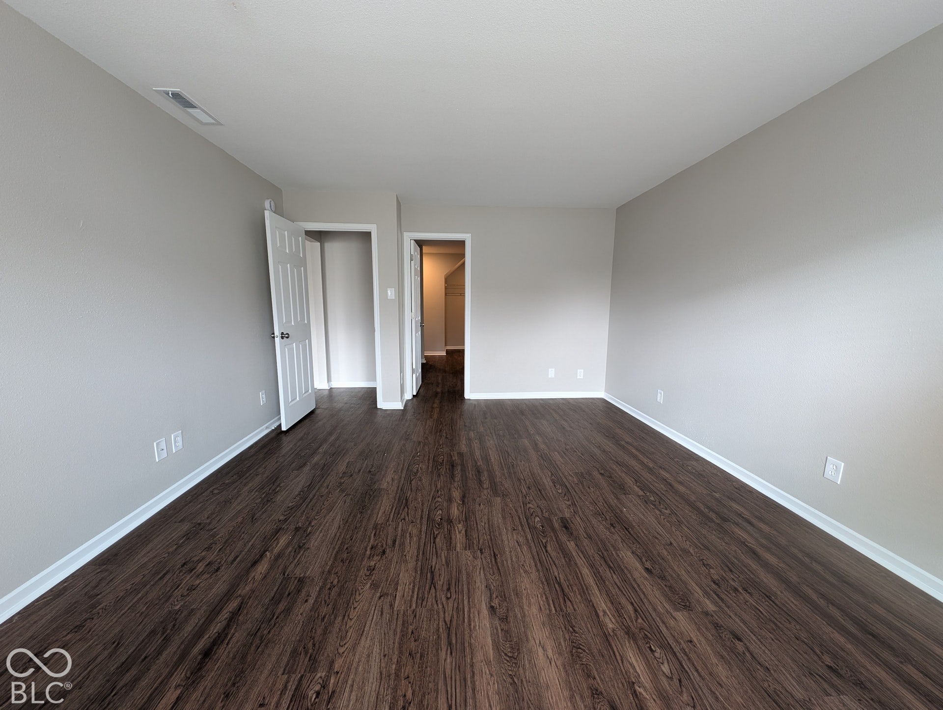 Wood-finish flooring throughout, light-colored wall paint, white trim, and white interior doors