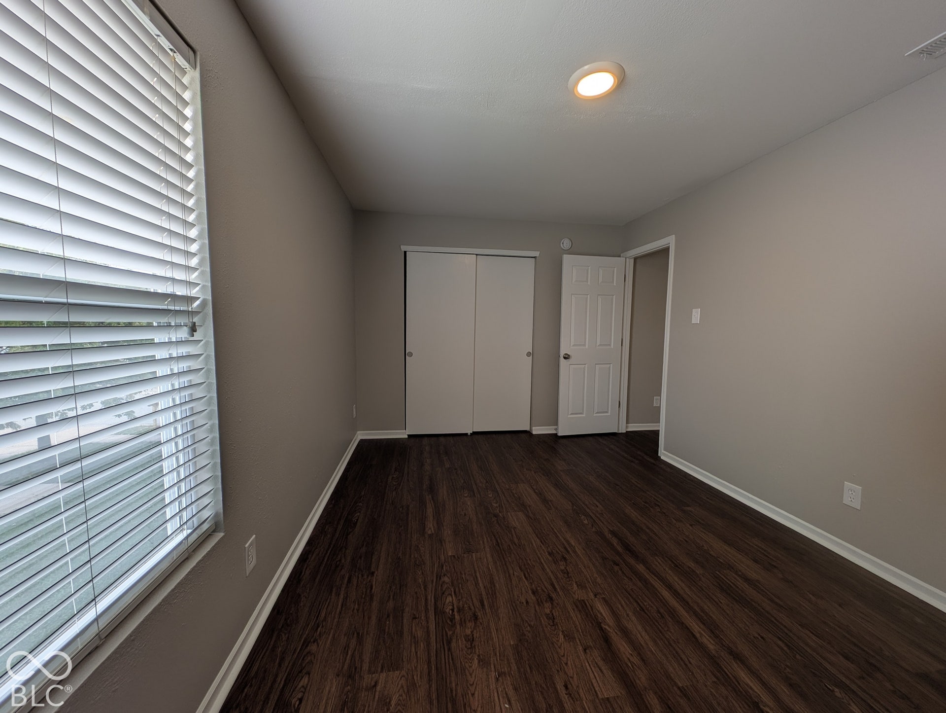 Recessed ceiling lighting, dark wood-finish flooring, and light neutral wall tones