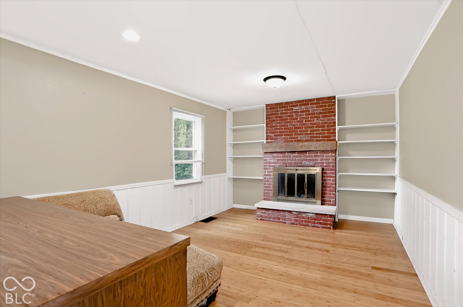 Hardwood flooring and brick-surround fireplace with hearth