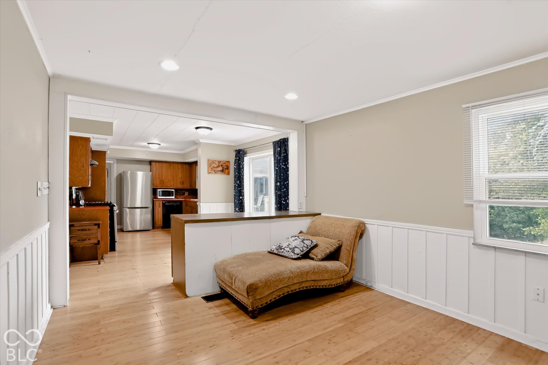Wood-finish flooring throughout, with a framed opening leading to the kitchen