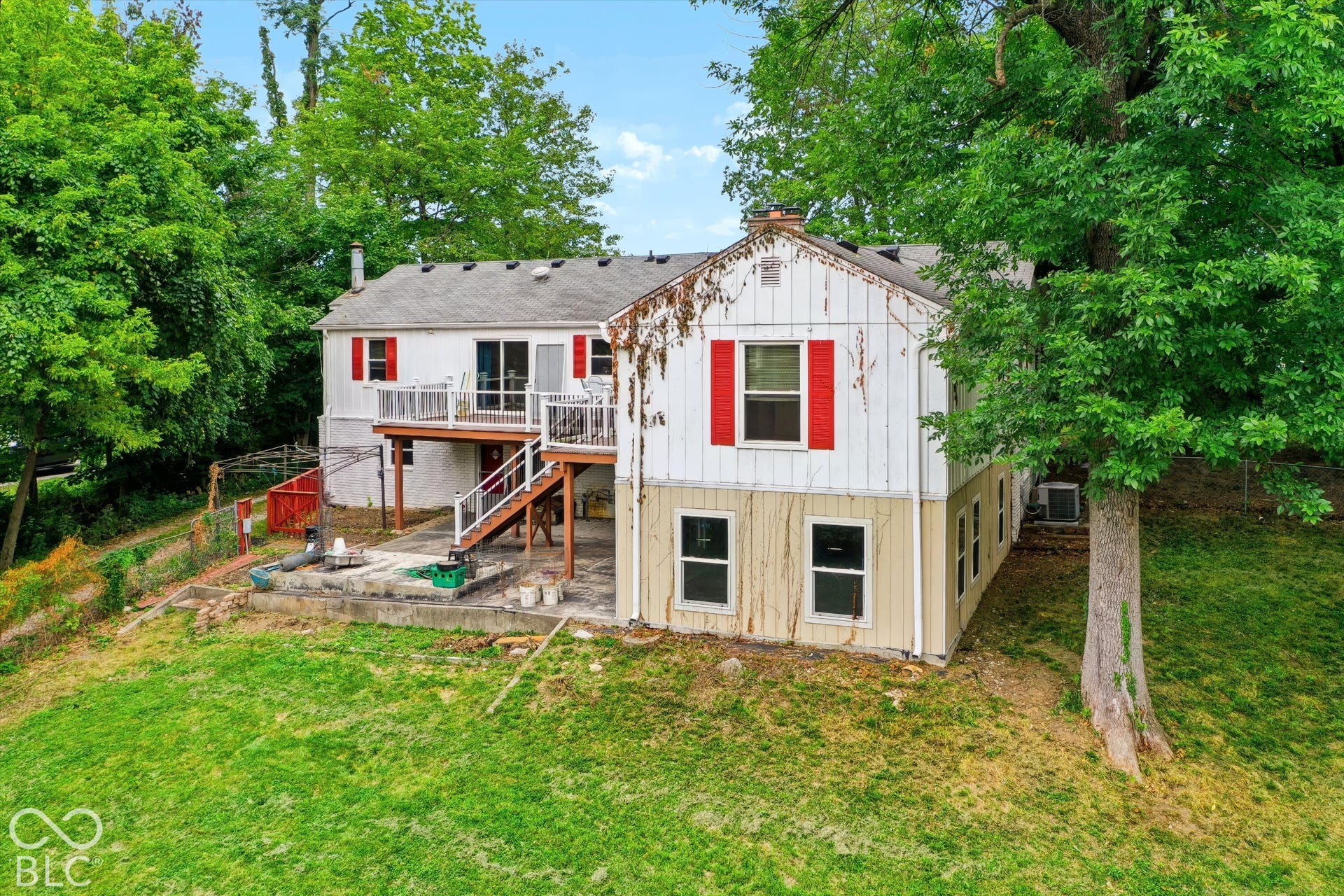 Multi-level property featuring white siding and red shutters