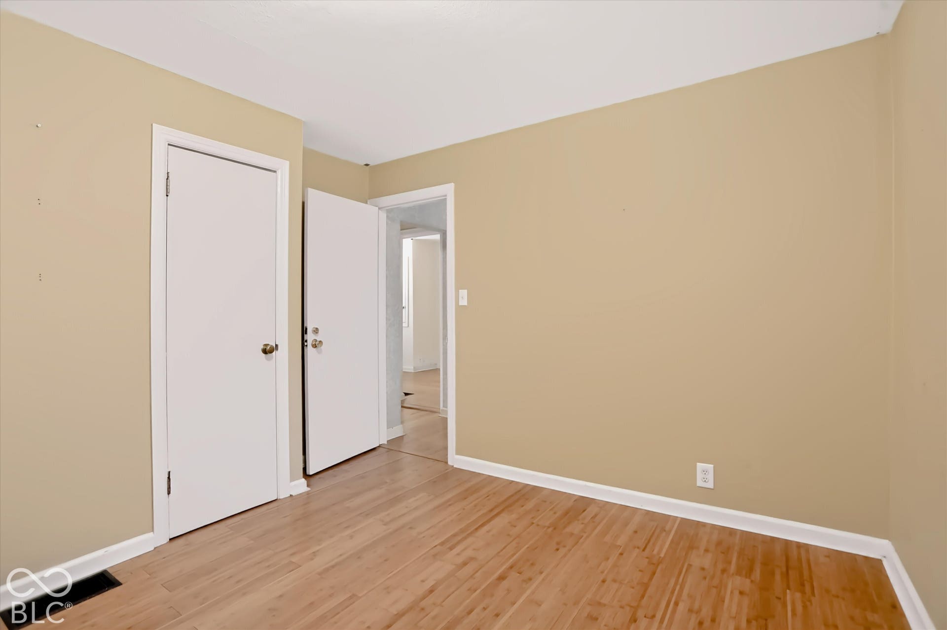 Wood-finish flooring with light-colored walls and white trim