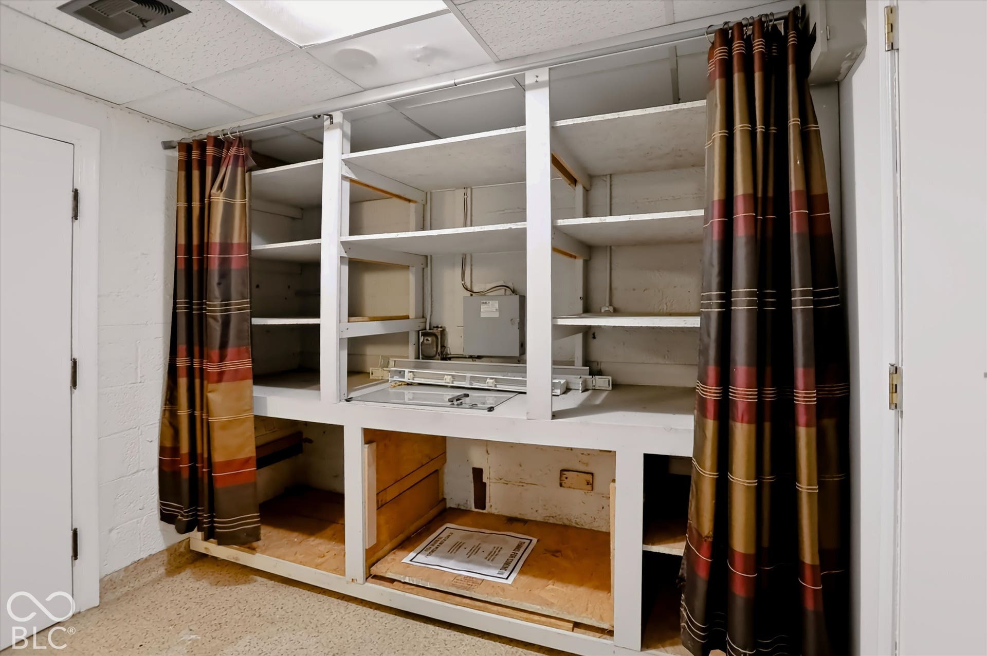 Built-in shelving unit with multiple open shelves and lower cabinet spaces