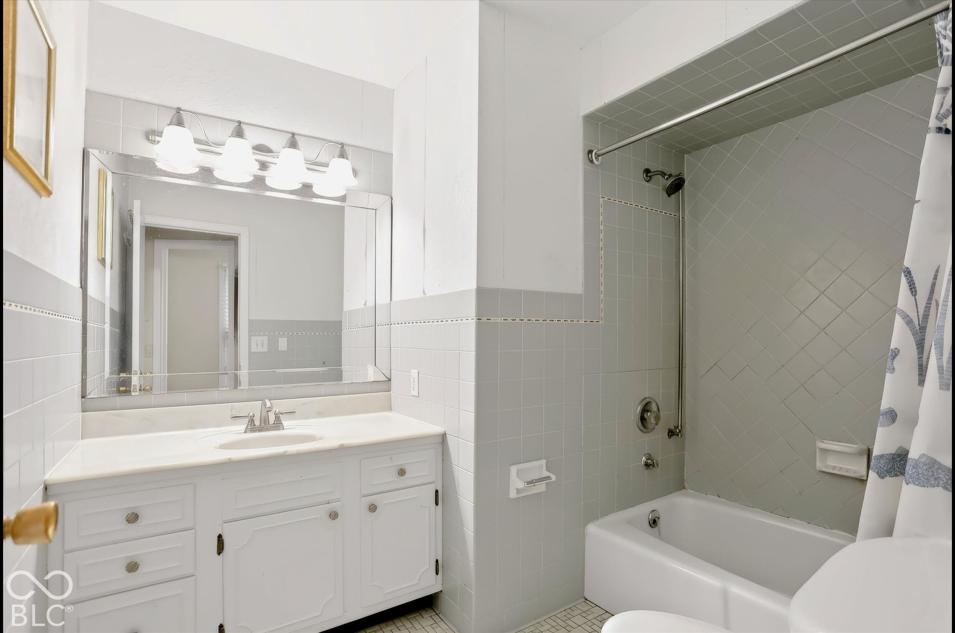 White vanity with ample storage, a single basin sink, and a light-toned countertop