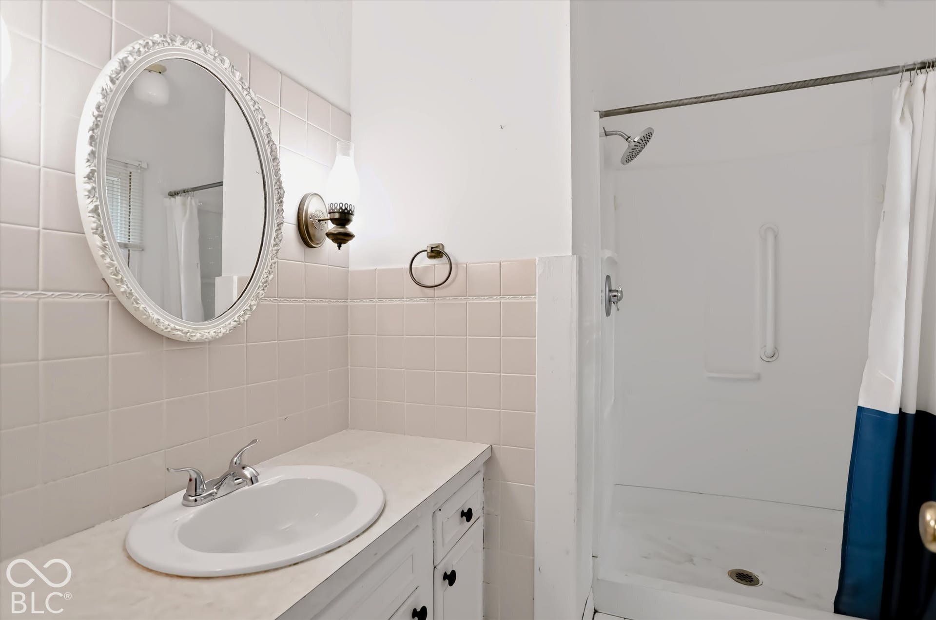White tiled shower with an integrated grab bar