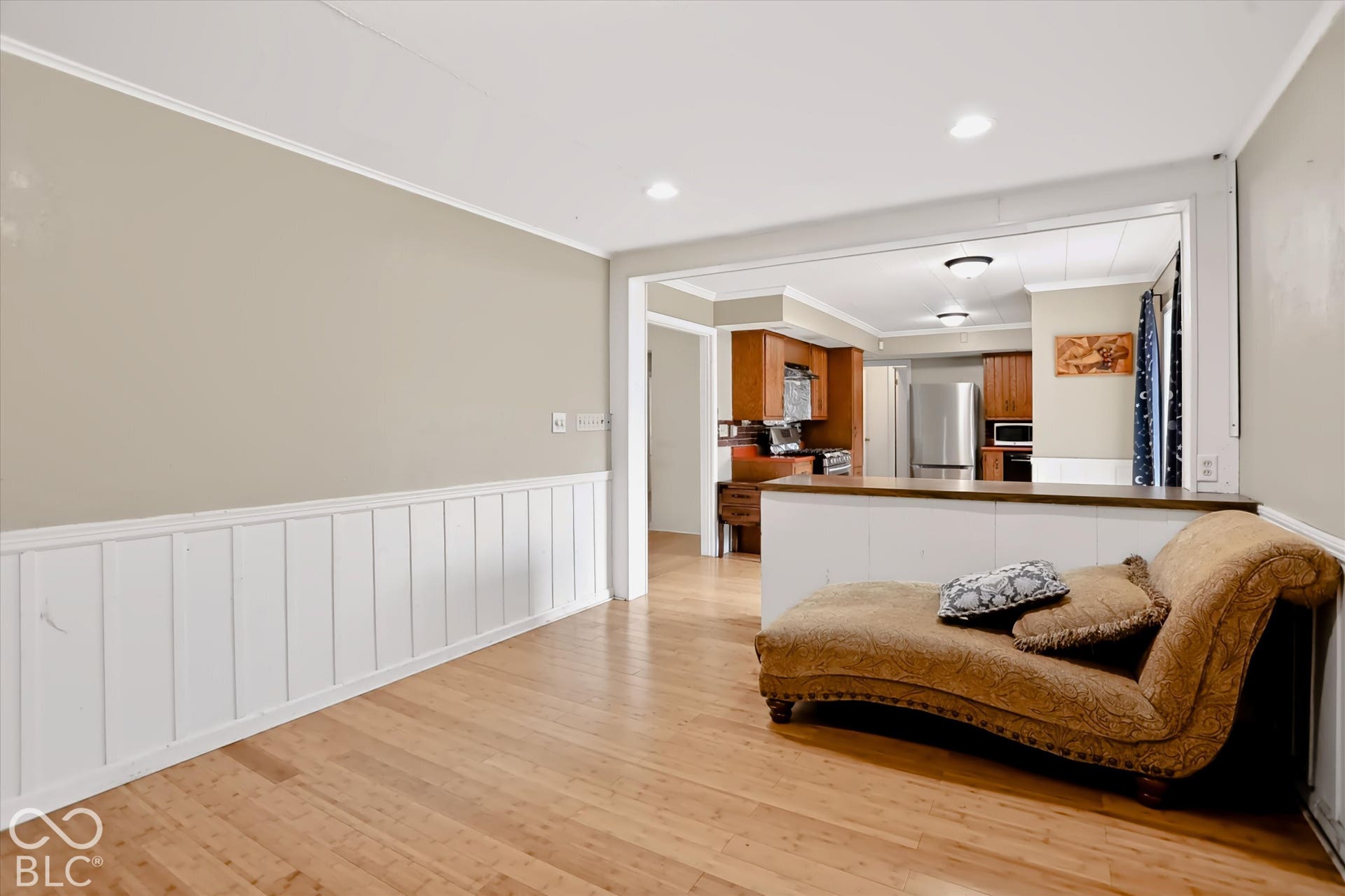 Wood-finish flooring throughout, white wainscoting, and recessed lighting