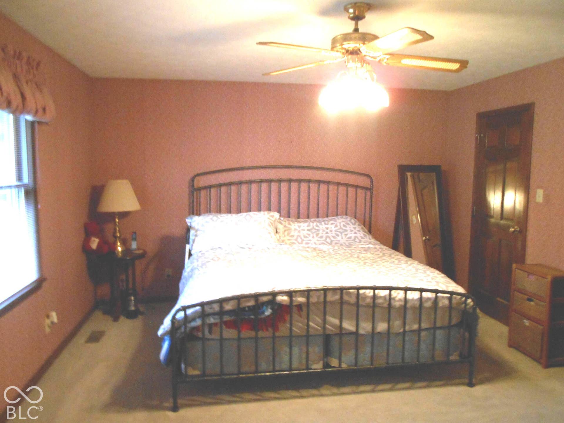 Window with valance, ceiling fan with light fixture, wall-to-wall carpeting, and wood-finish door